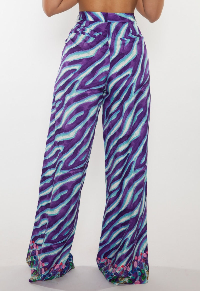 Purple and blue zebra patterned pants on a white background