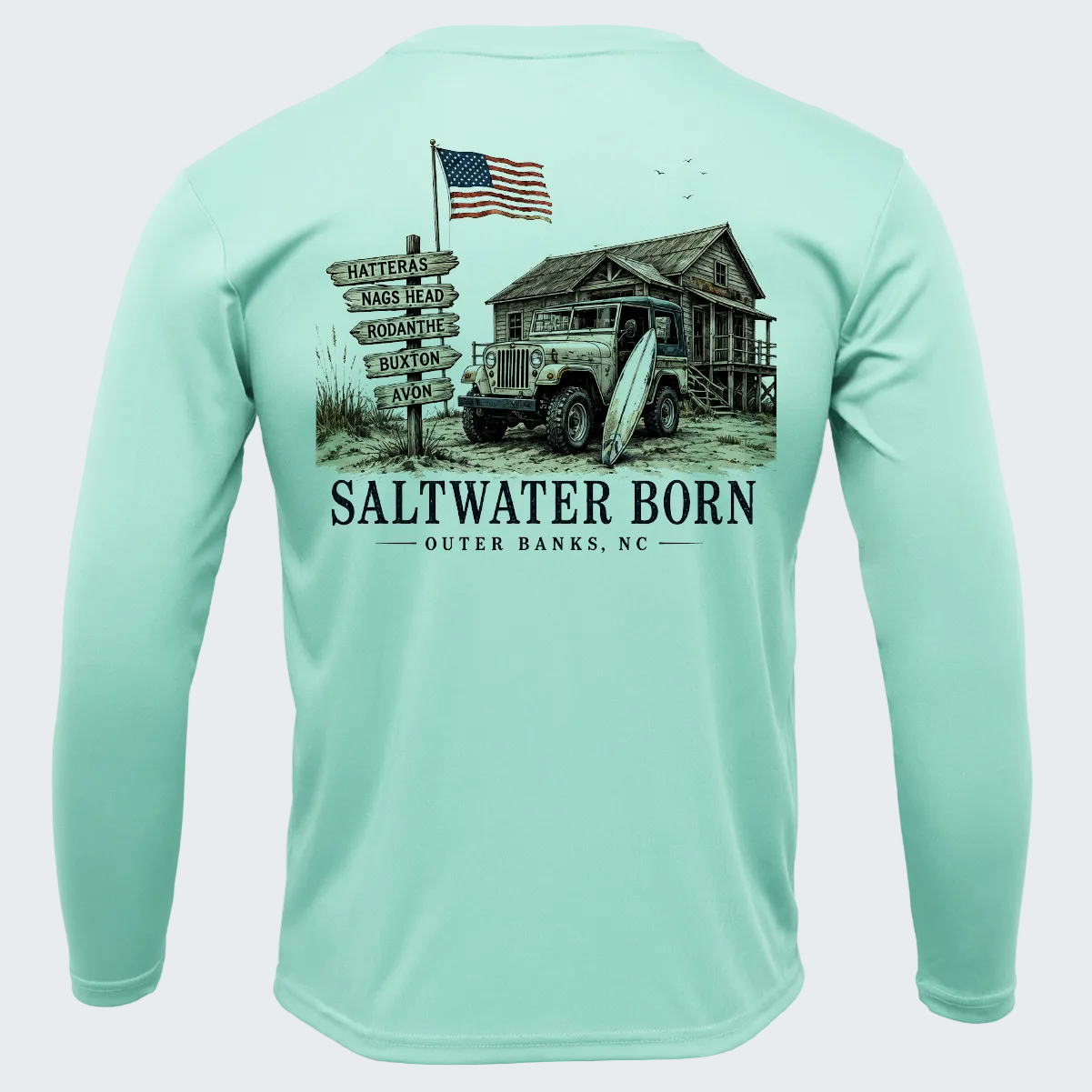 A mint green long-sleeve performance shirt shown from the back, featuring a large graphic print of a vintage truck, a rustic cabin, an American flag, and a signpost with 'SALTWATER BORN OUTER BANKS, NC' text.