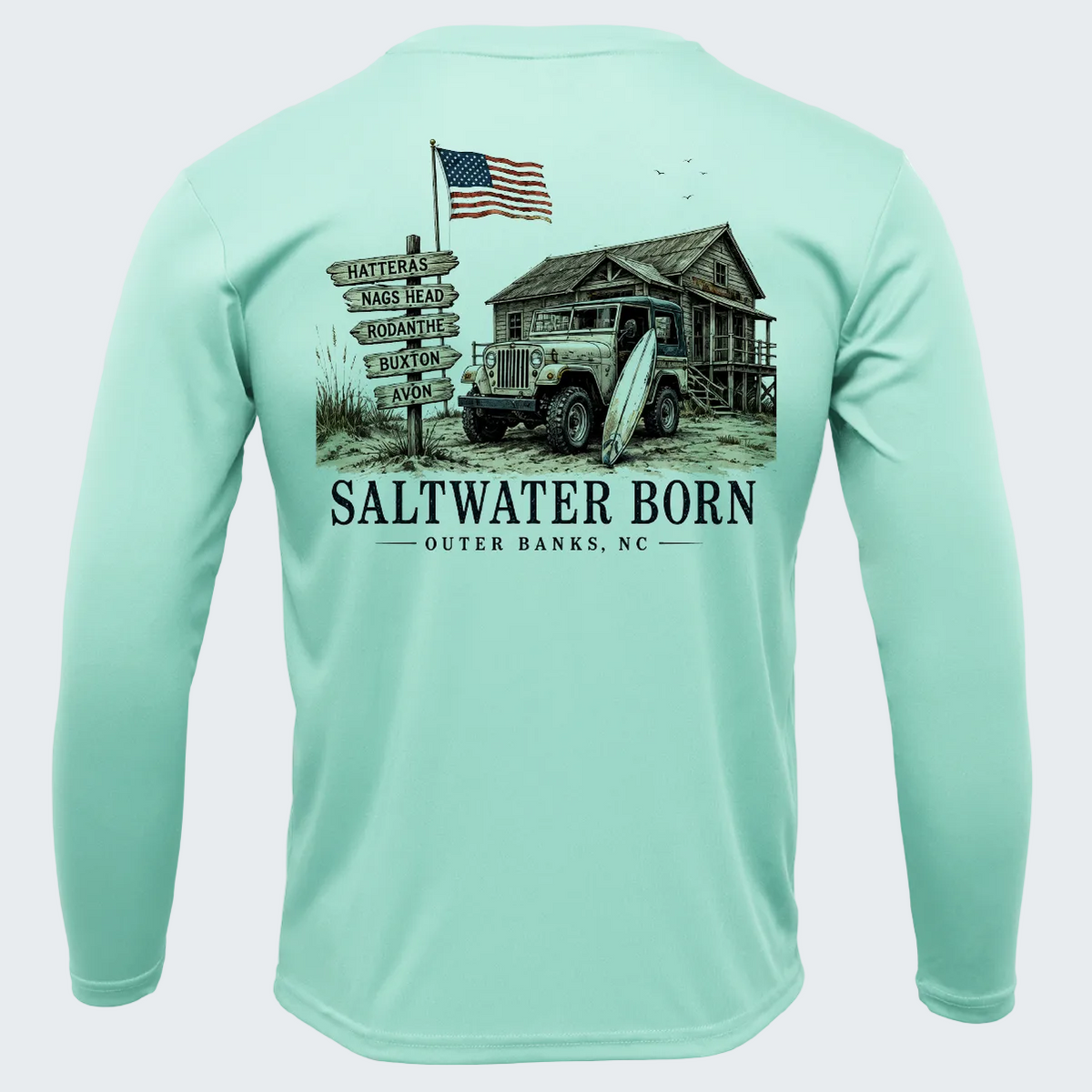 A mint green long-sleeve performance shirt shown from the back, featuring a large graphic print of a vintage truck, a rustic cabin, an American flag, and a signpost with 'SALTWATER BORN OUTER BANKS, NC' text.