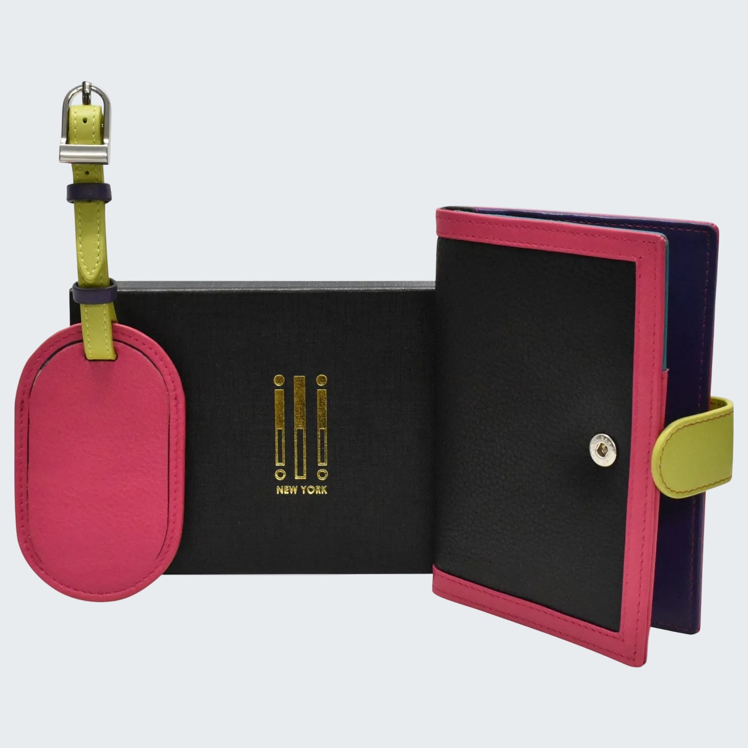 A colorful leather travel organizer set featuring a black textured case with magenta pink trim, a matching oval luggage tag, and a lime green strap, displayed on a clean white background.