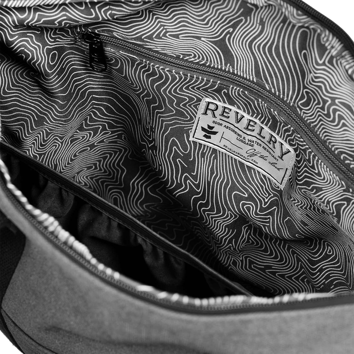 Close-up of a backpack with a topographic pattern and 'Revelry' brand label.