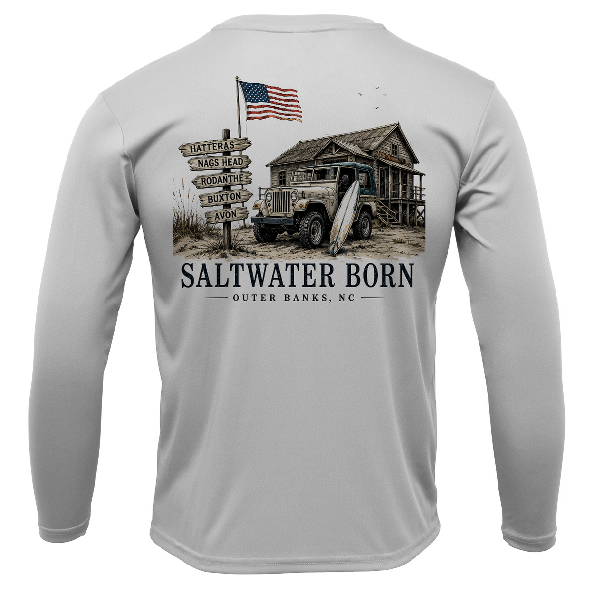 A light gray long-sleeve performance shirt shown from the back, featuring a large graphic print of a rustic cabin, vintage truck, surfboard, wooden signpost with local addresses, and an American flag. The text 'SALTWATER BORN OUTER BANKS, NC' is printed below the graphic.