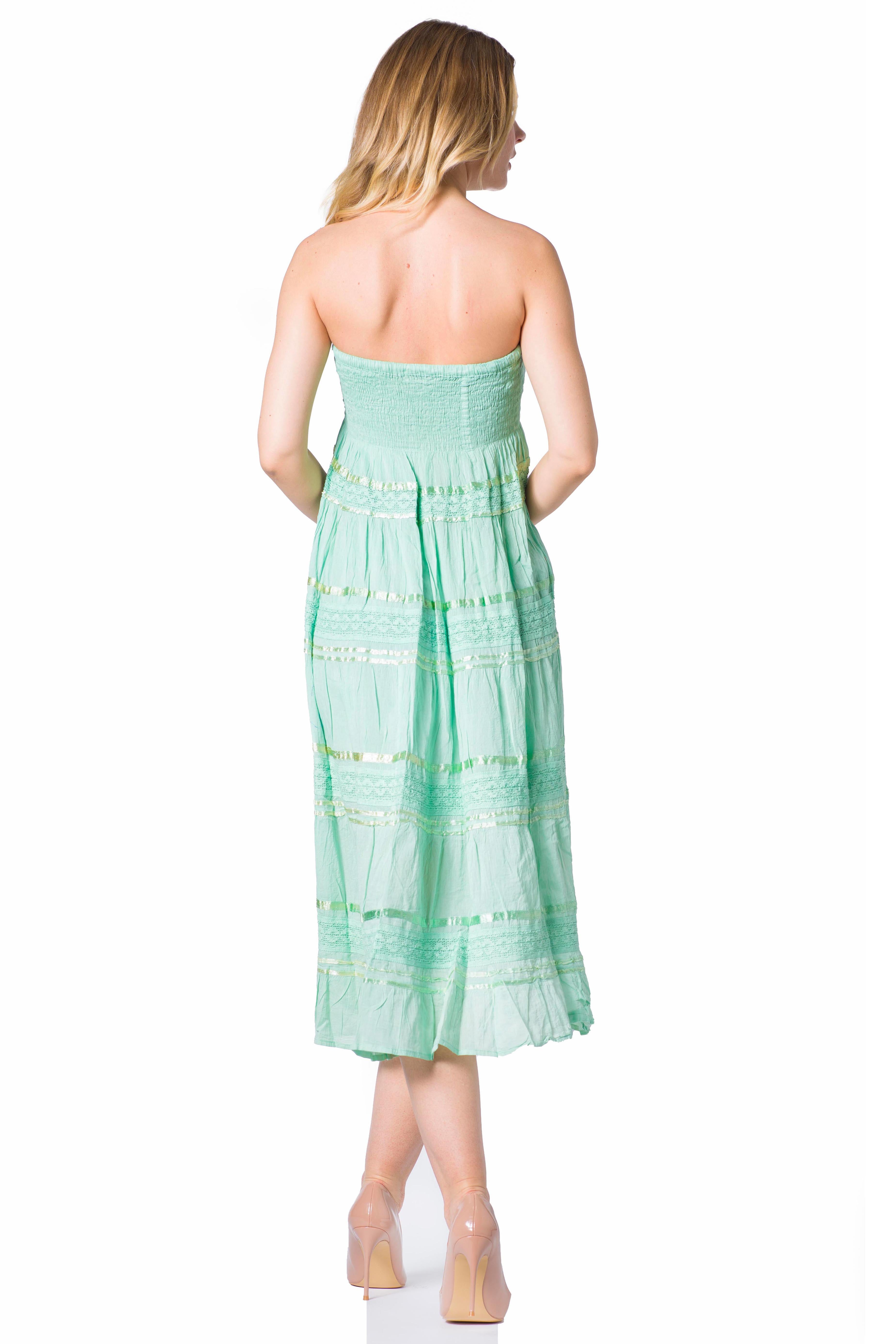 Woman wearing a light green strapless dress on a white background