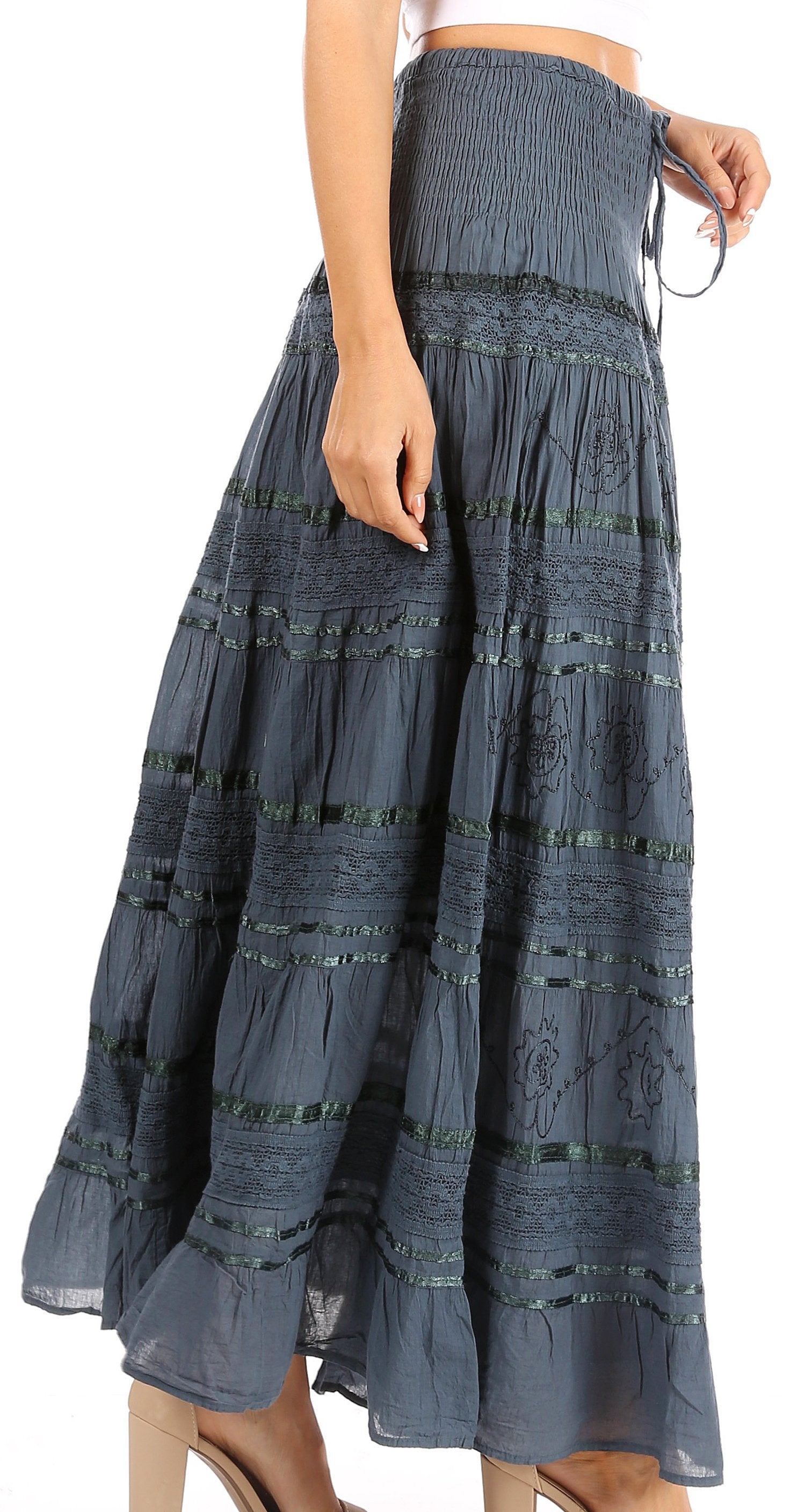 Long blue skirt with black patterns worn by a person on a white background