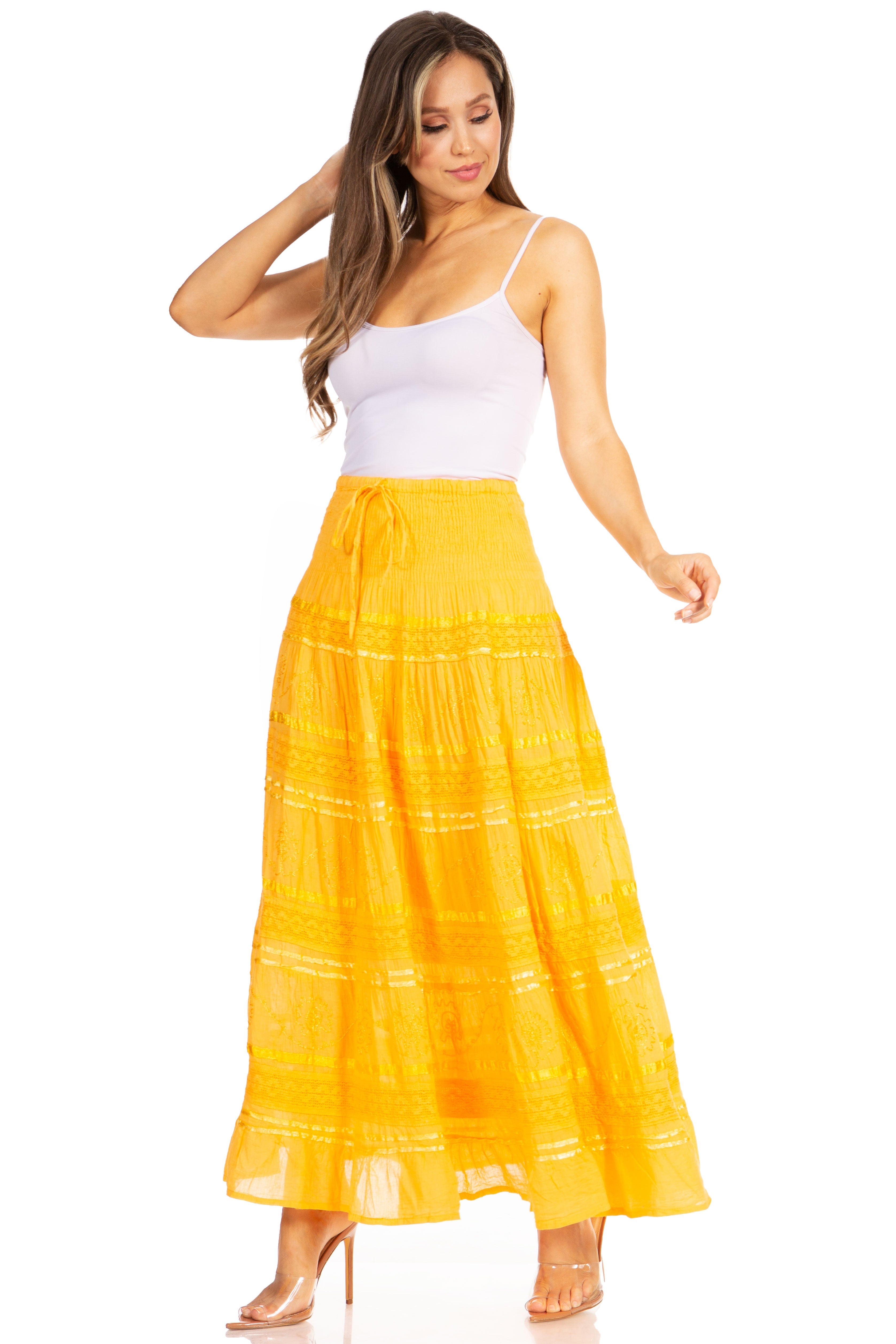 Woman wearing a yellow skirt with white patterns on a white background