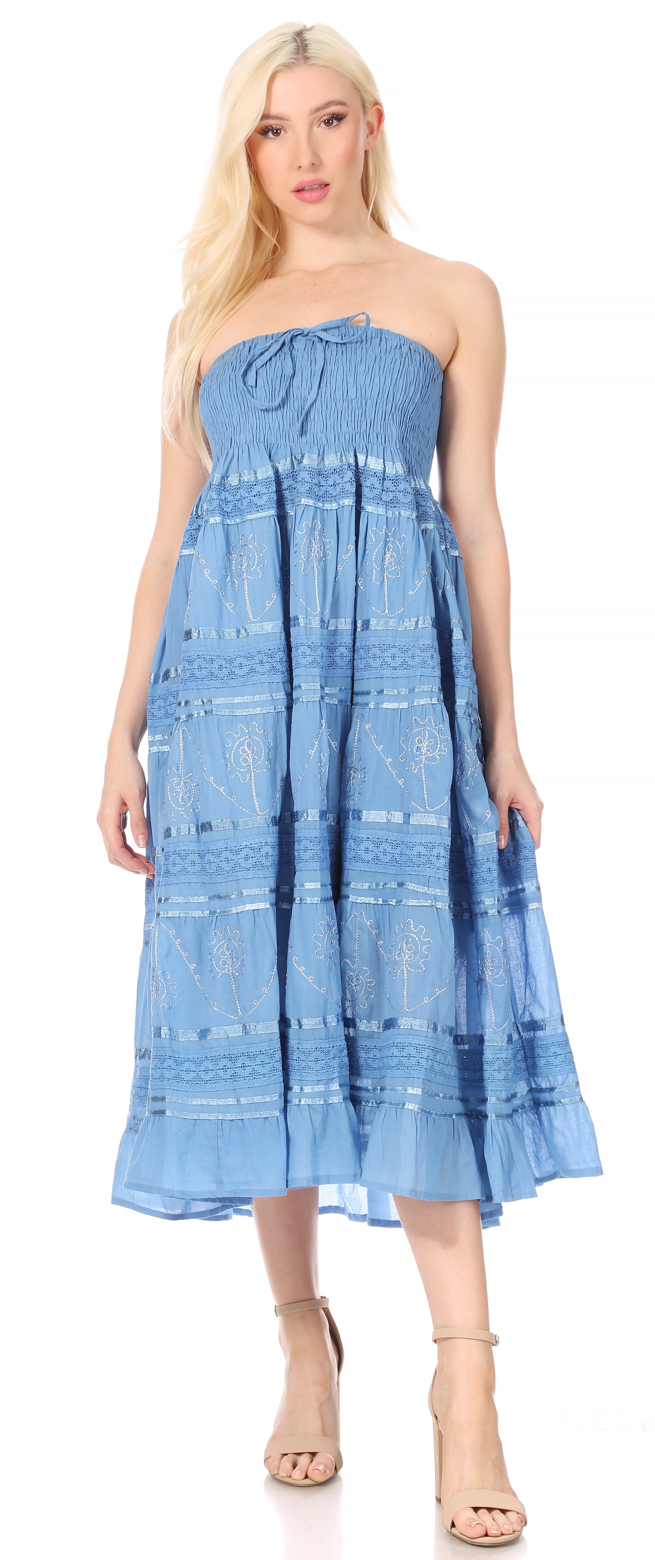 Woman wearing a blue strapless dress with a white pattern on a white background