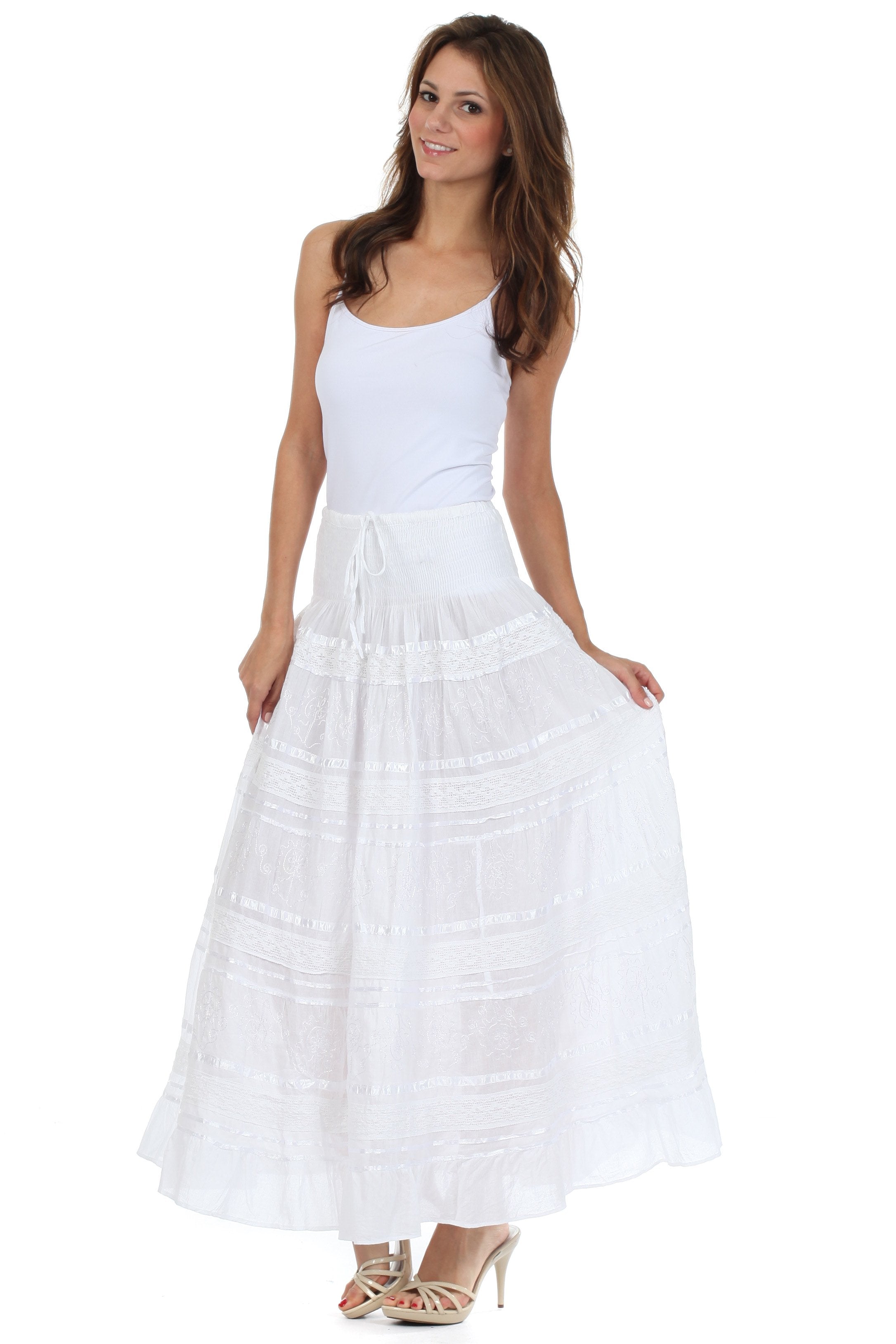 Woman wearing a white sleeveless top and long white skirt on a white background