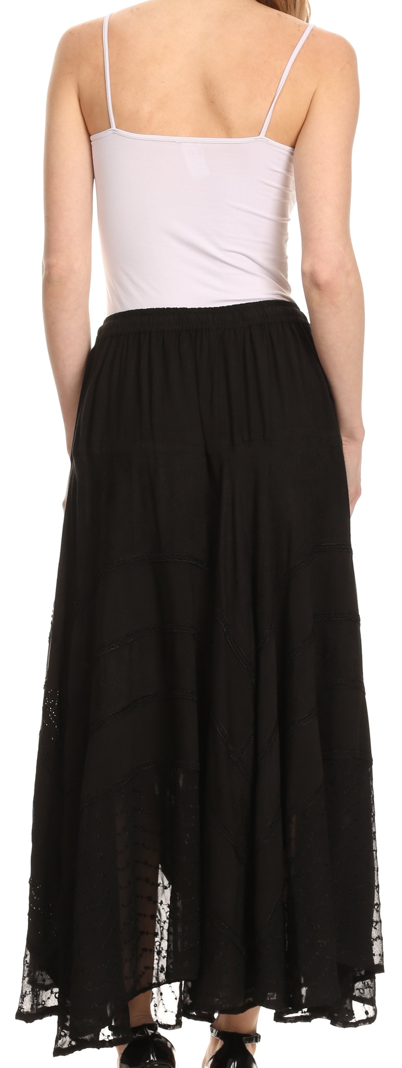 Person wearing a white top and black skirt with sheer sides.