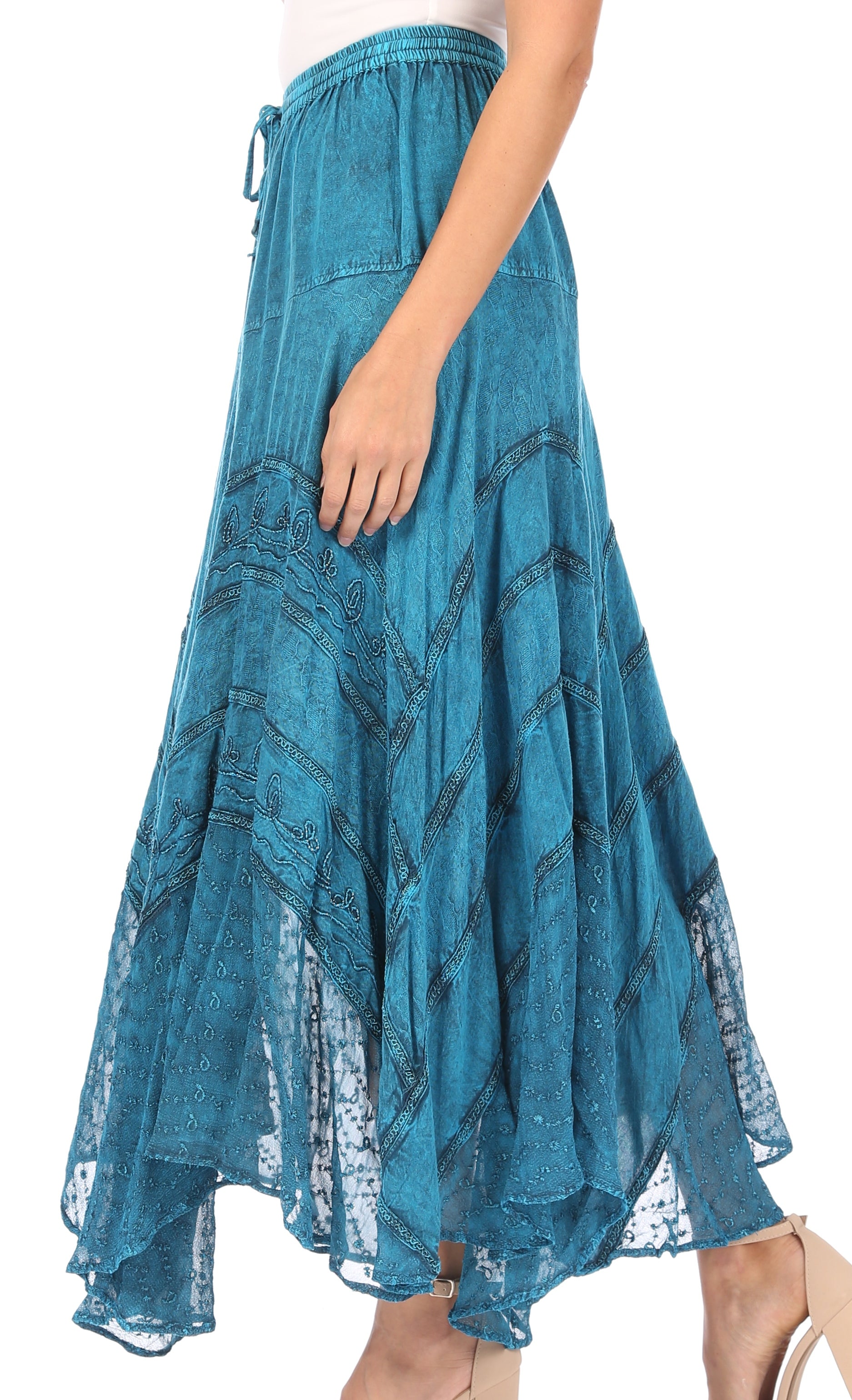 Teal patterned skirt worn by a person on a white background