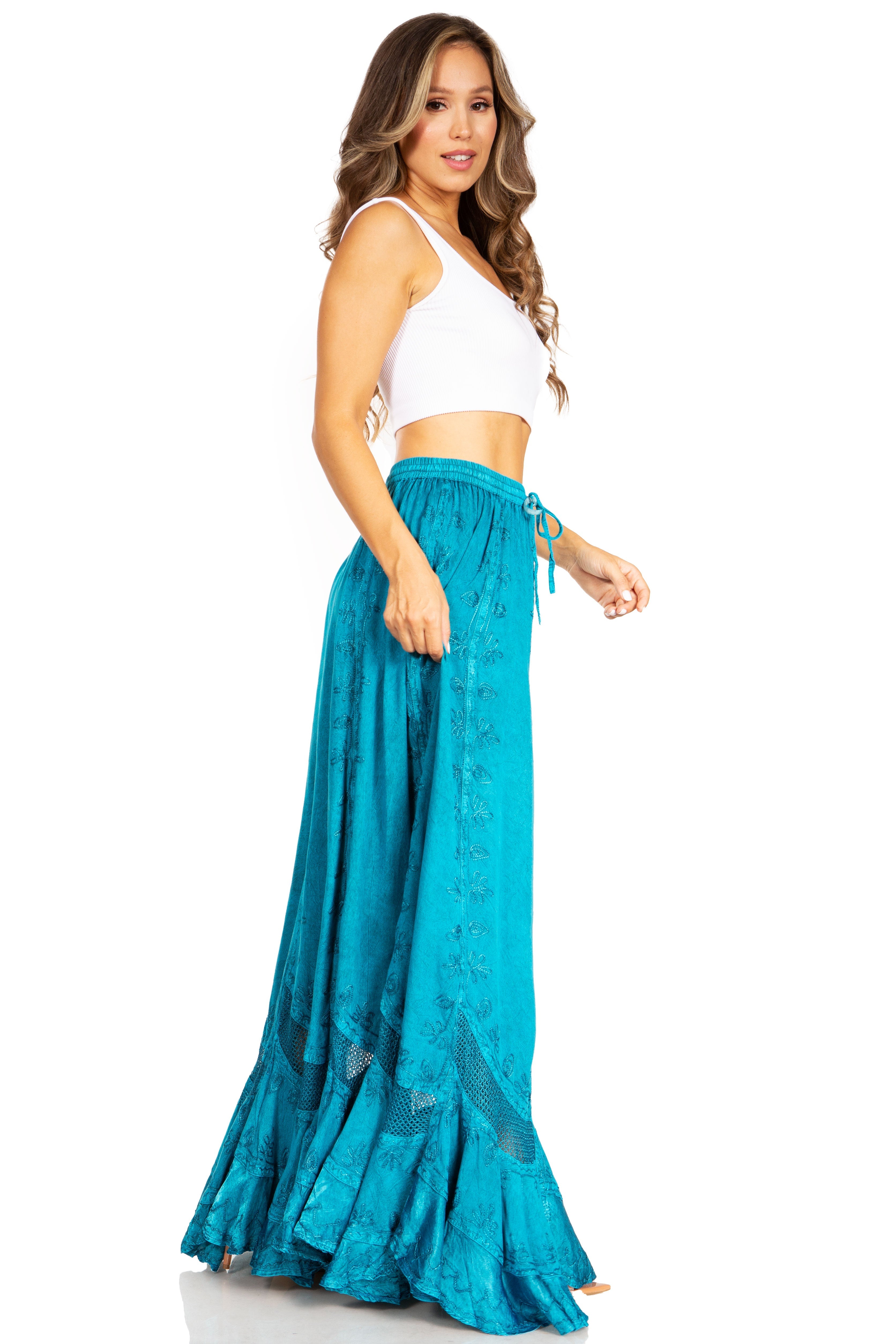 Woman wearing a white top and teal skirt on a white background