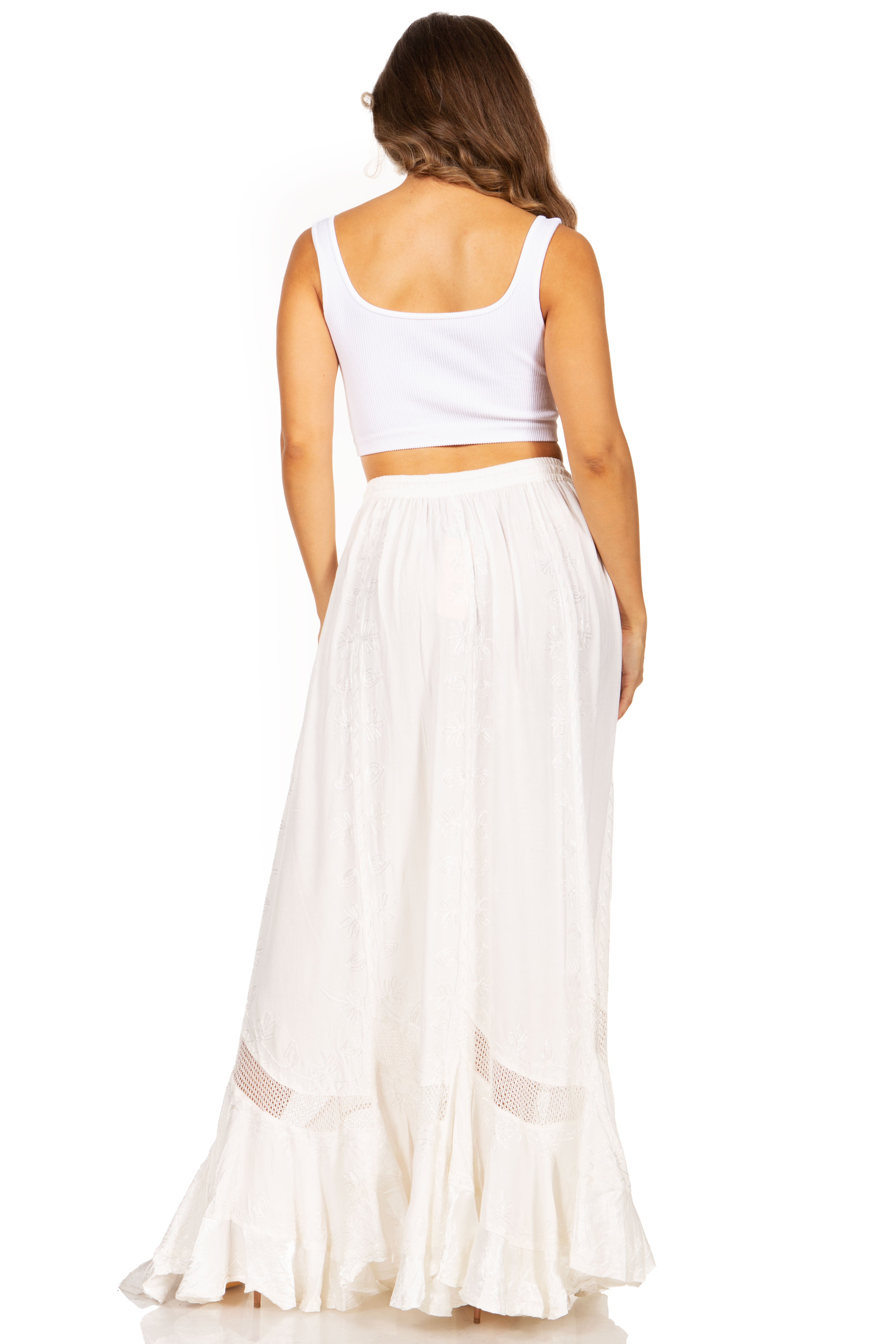 Woman wearing a white sleeveless top and long skirt on a white background