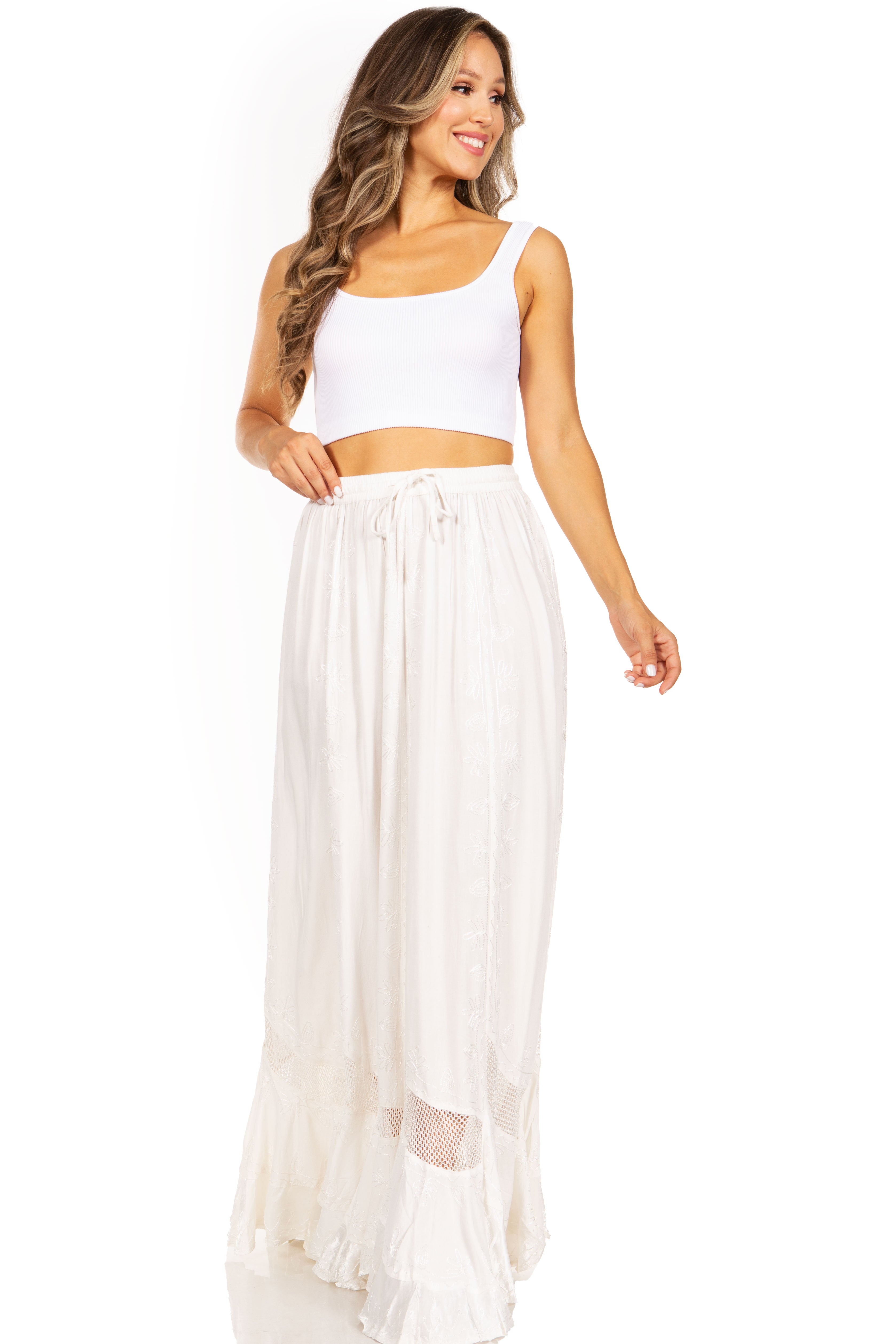 Woman wearing a white sleeveless top and long skirt on a white background