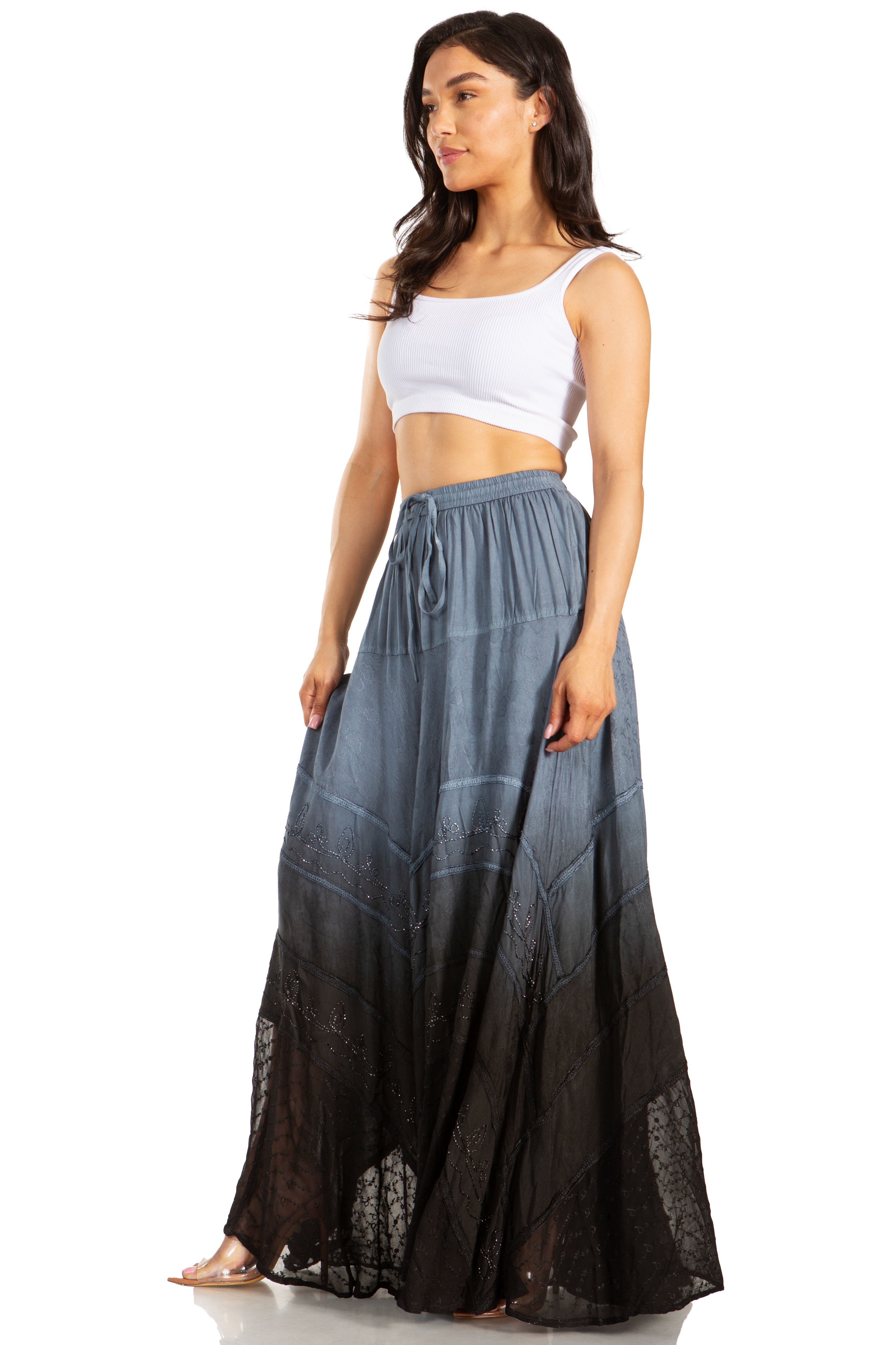 Woman wearing a long, dark gray skirt with a white top on a white background