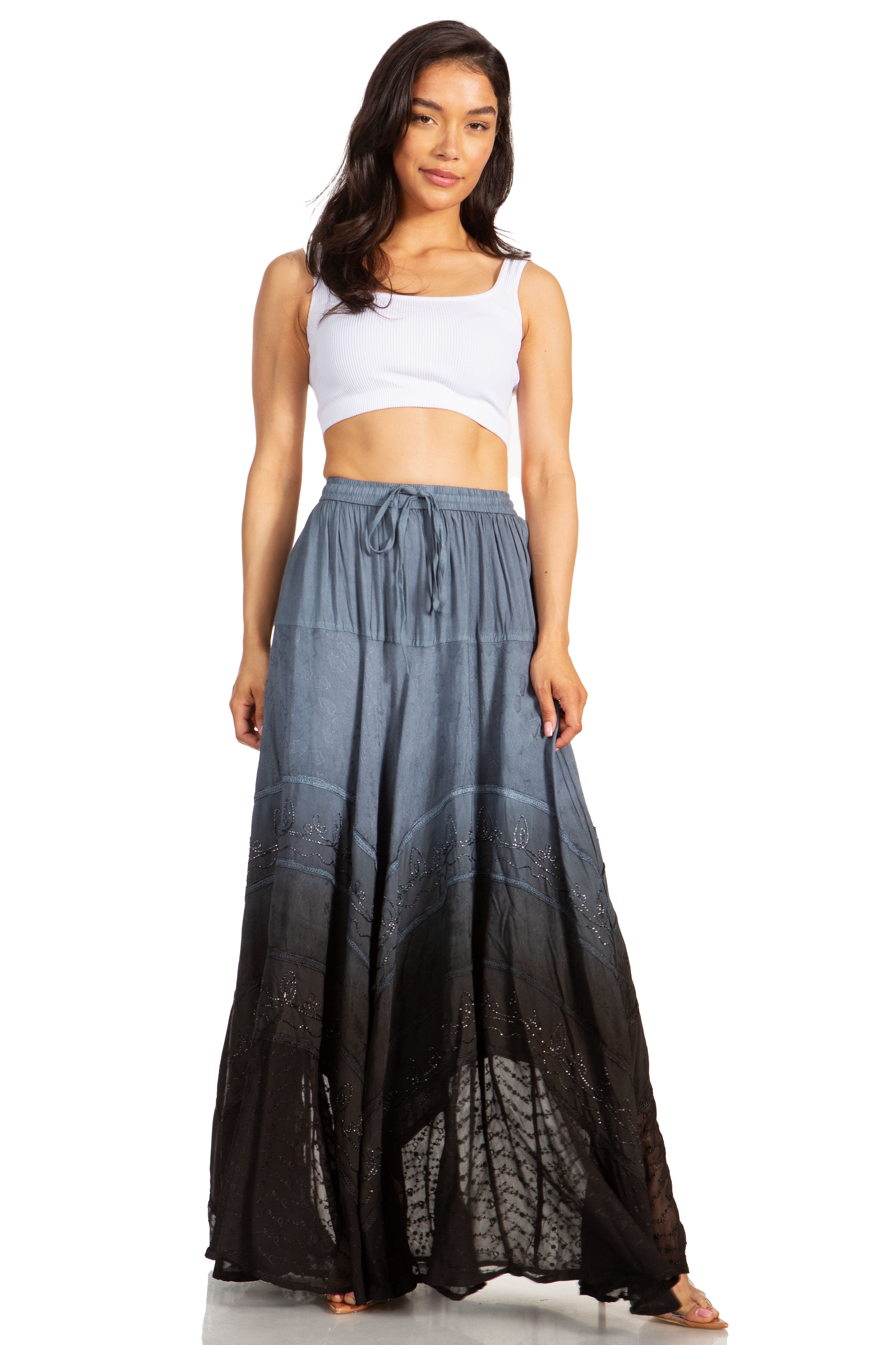 Woman wearing a white top and a long, gradient skirt on a white background
