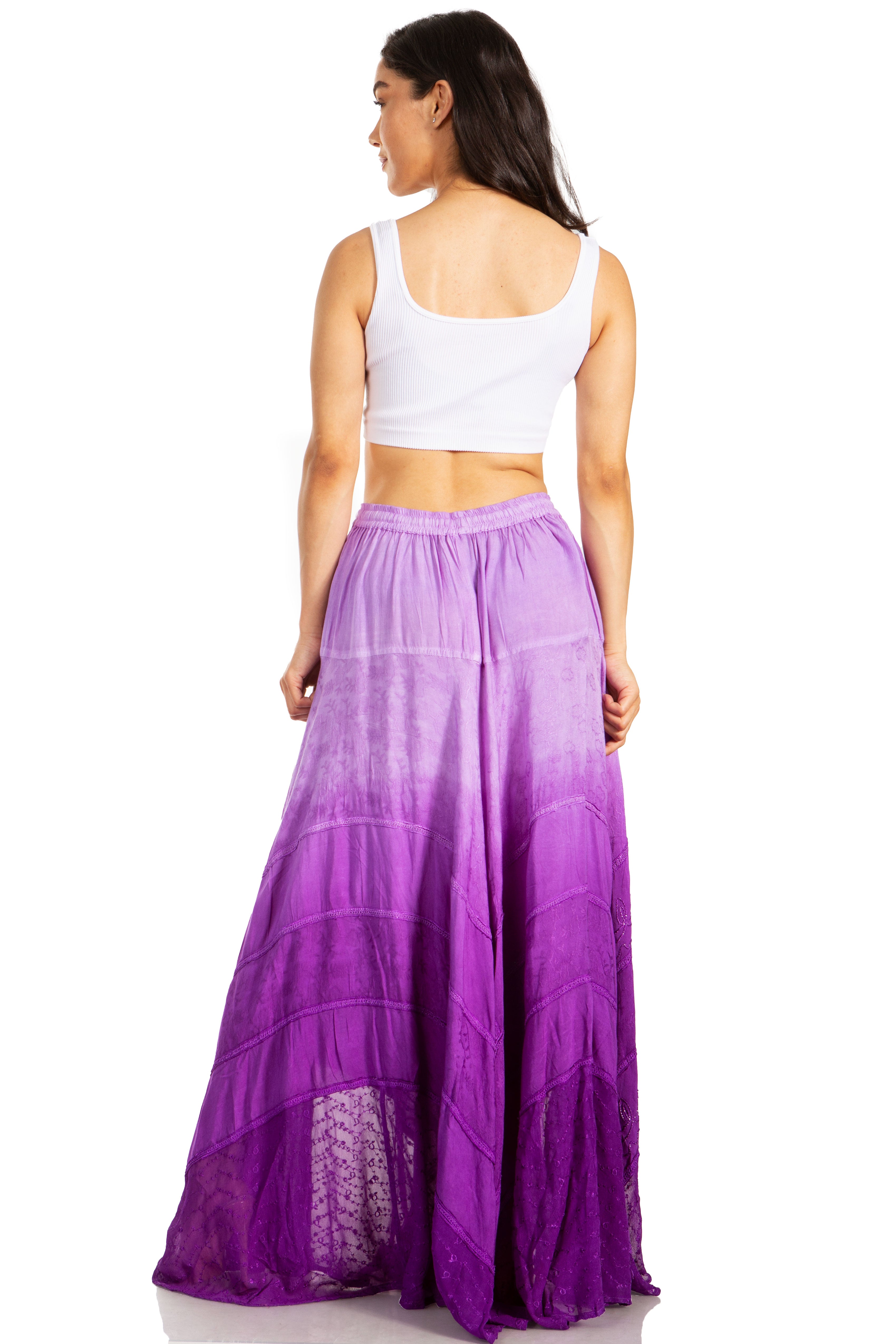 Woman wearing a long purple skirt with a white top on a white background
