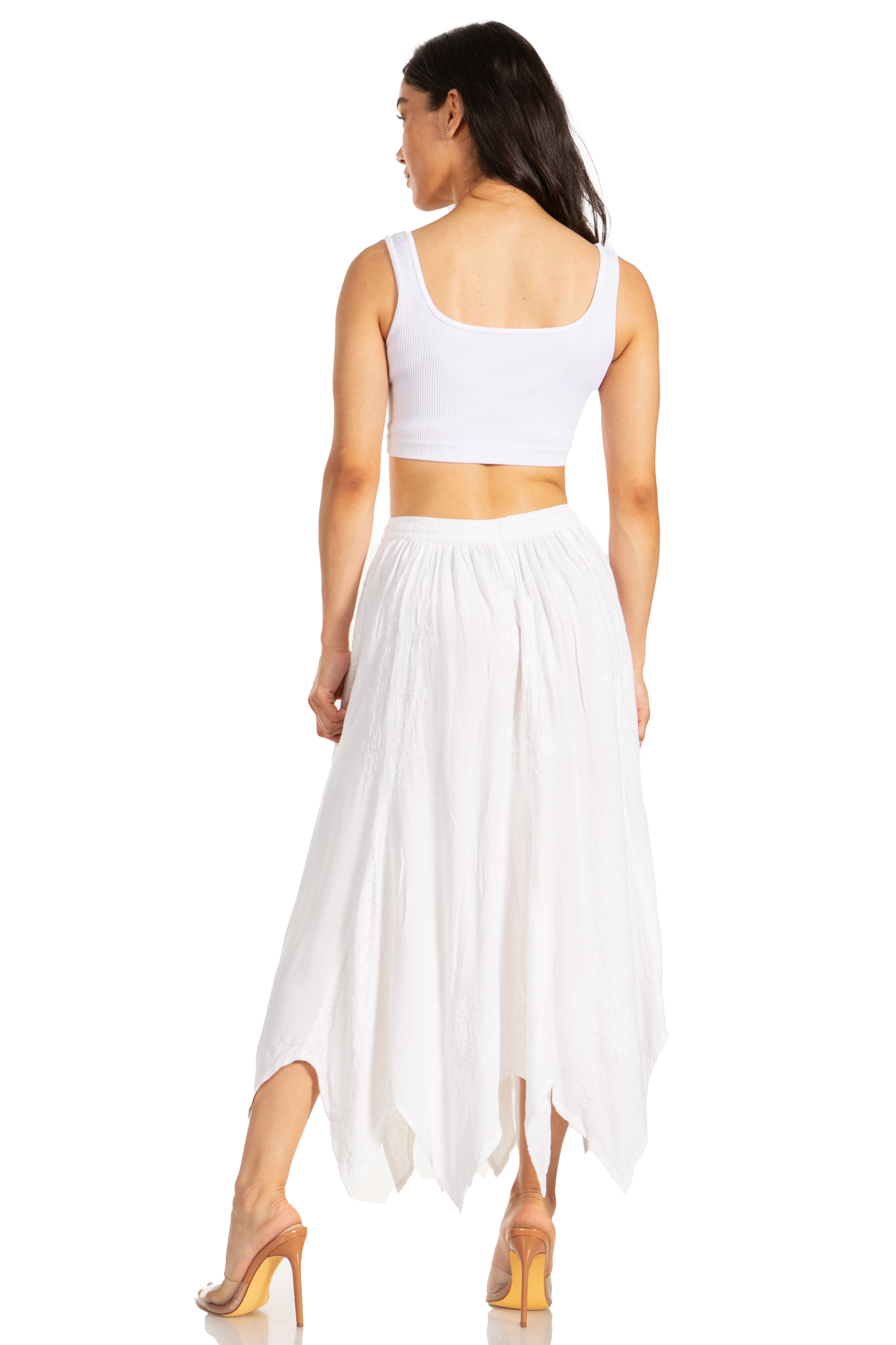 Woman wearing a white sleeveless top and long skirt on a white background