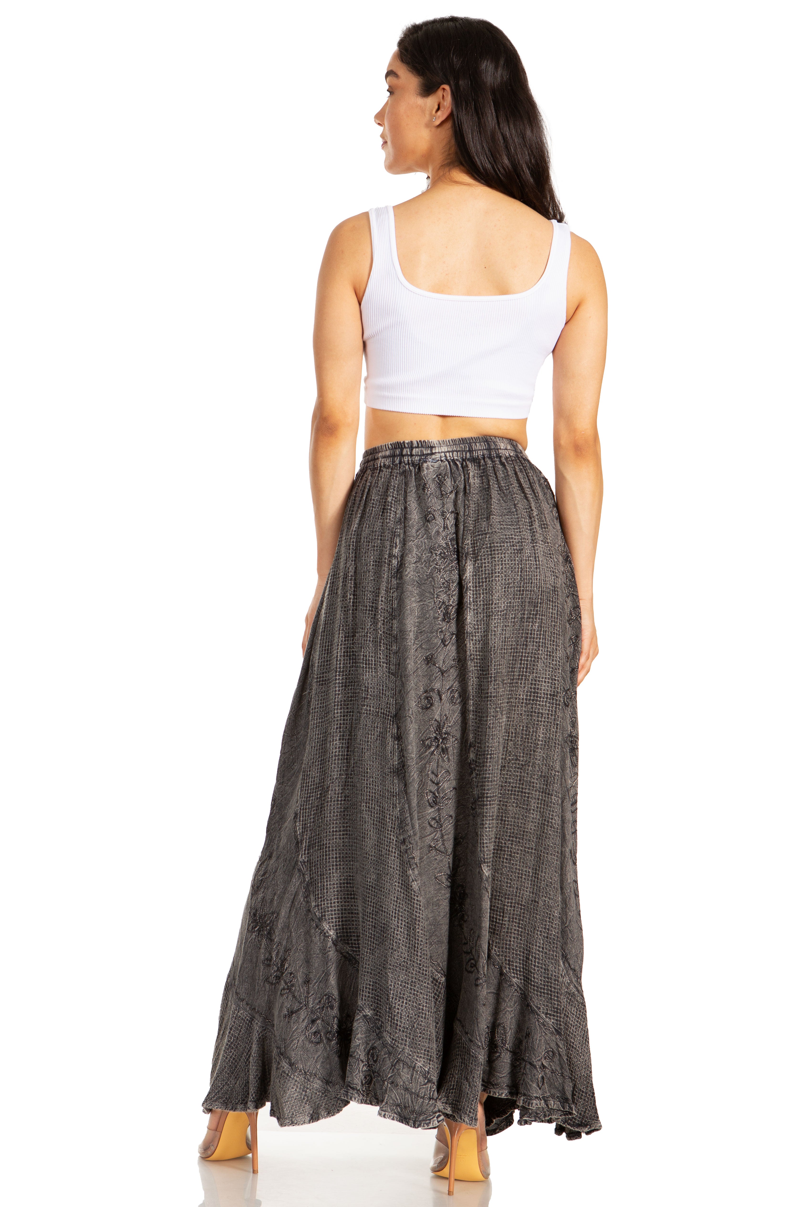 Woman wearing a white top and long dark gray skirt on a white background