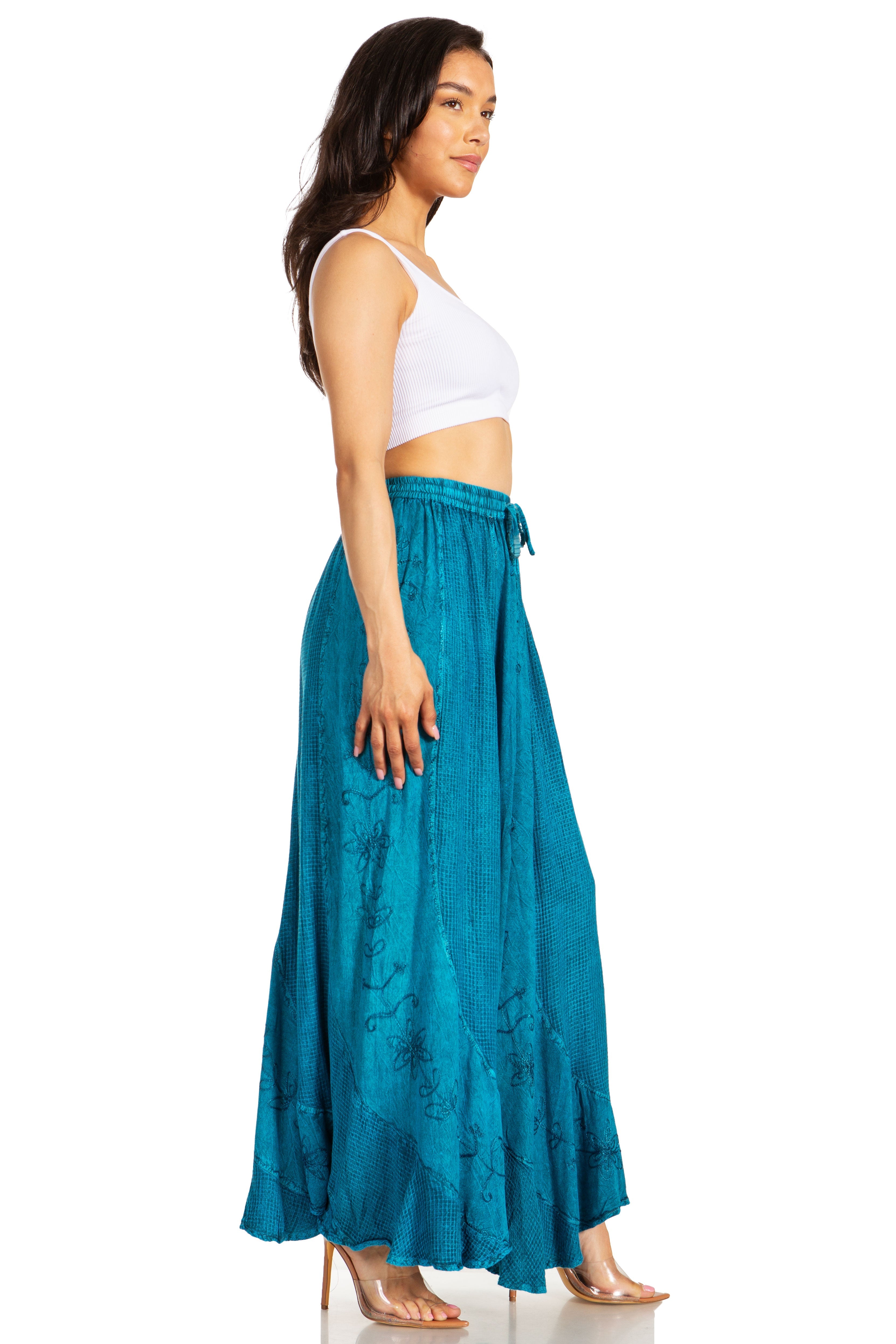 Woman wearing a white top and teal skirt on a white background