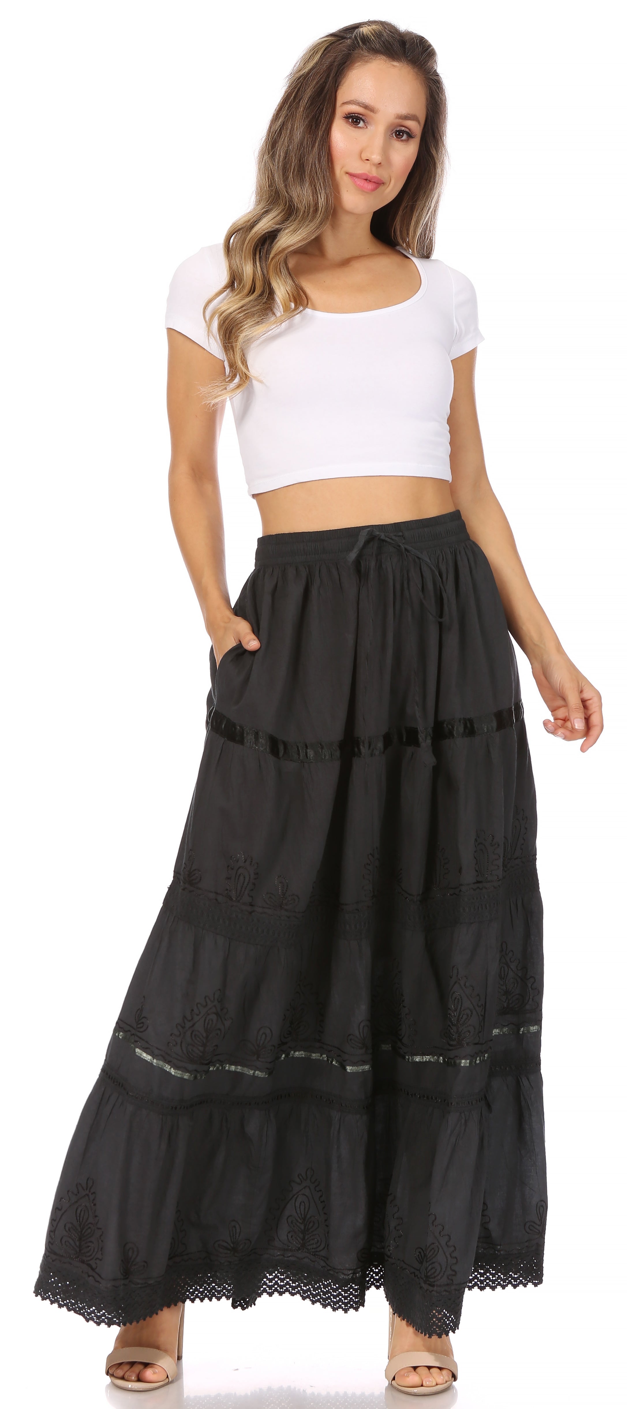 Woman wearing a black long skirt and white top on a white background