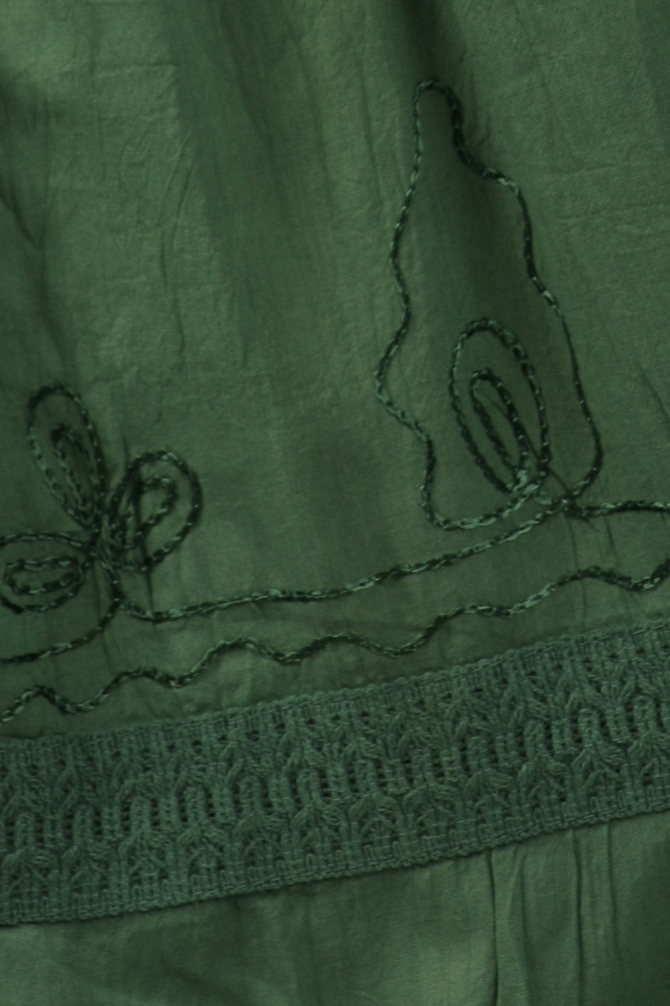 Green fabric with embroidered patterns