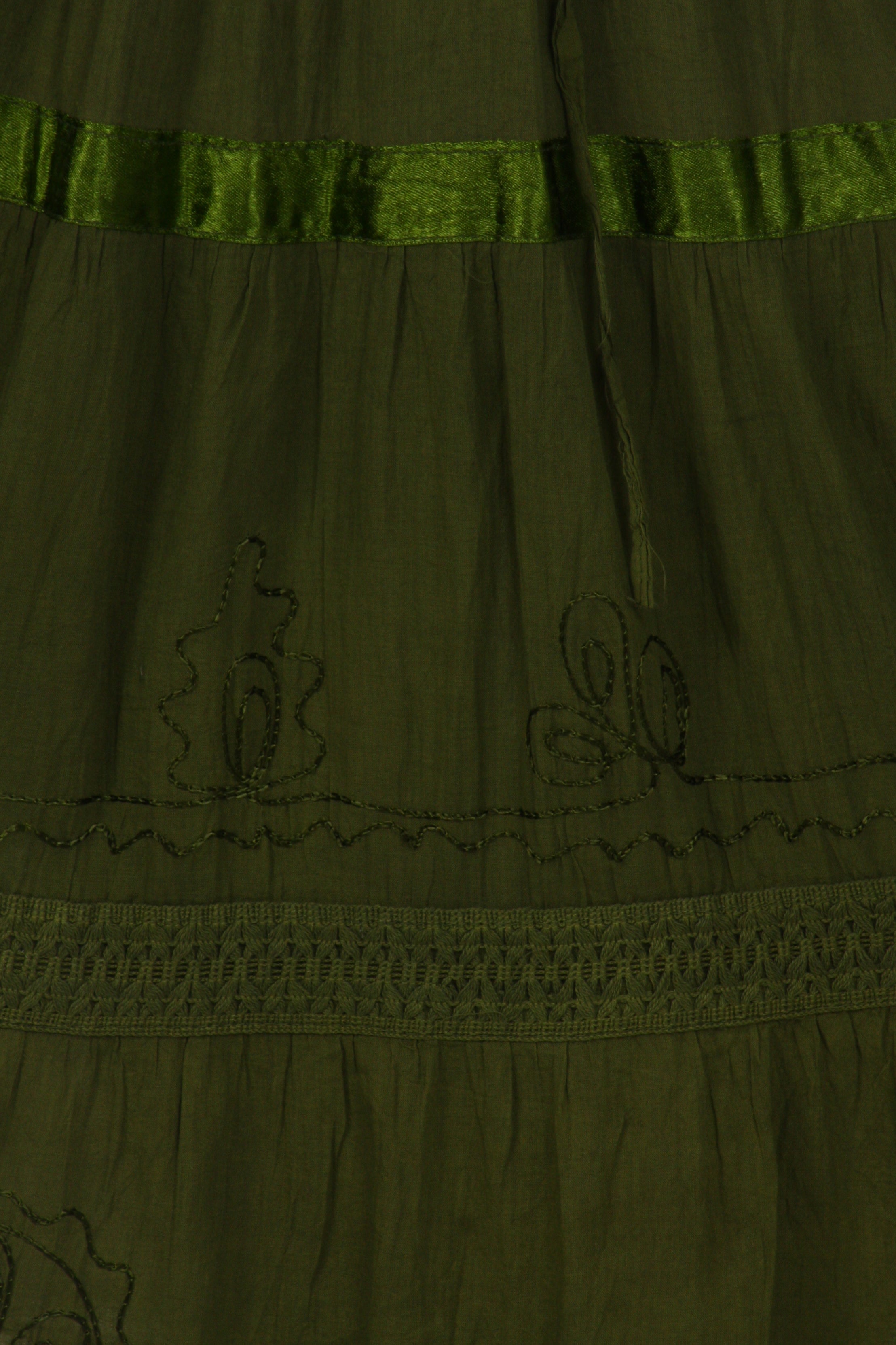 Green dress with embroidery details on a plain background