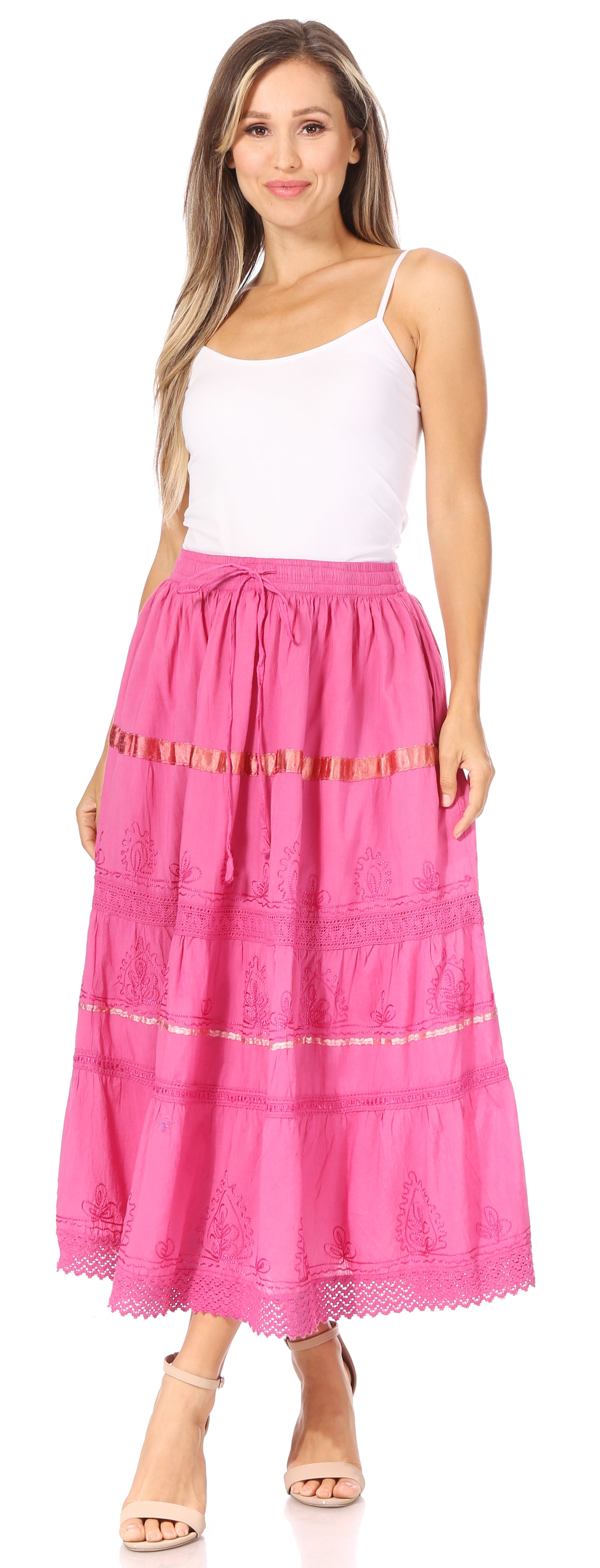 Woman wearing a pink tiered skirt with a white top on a white background