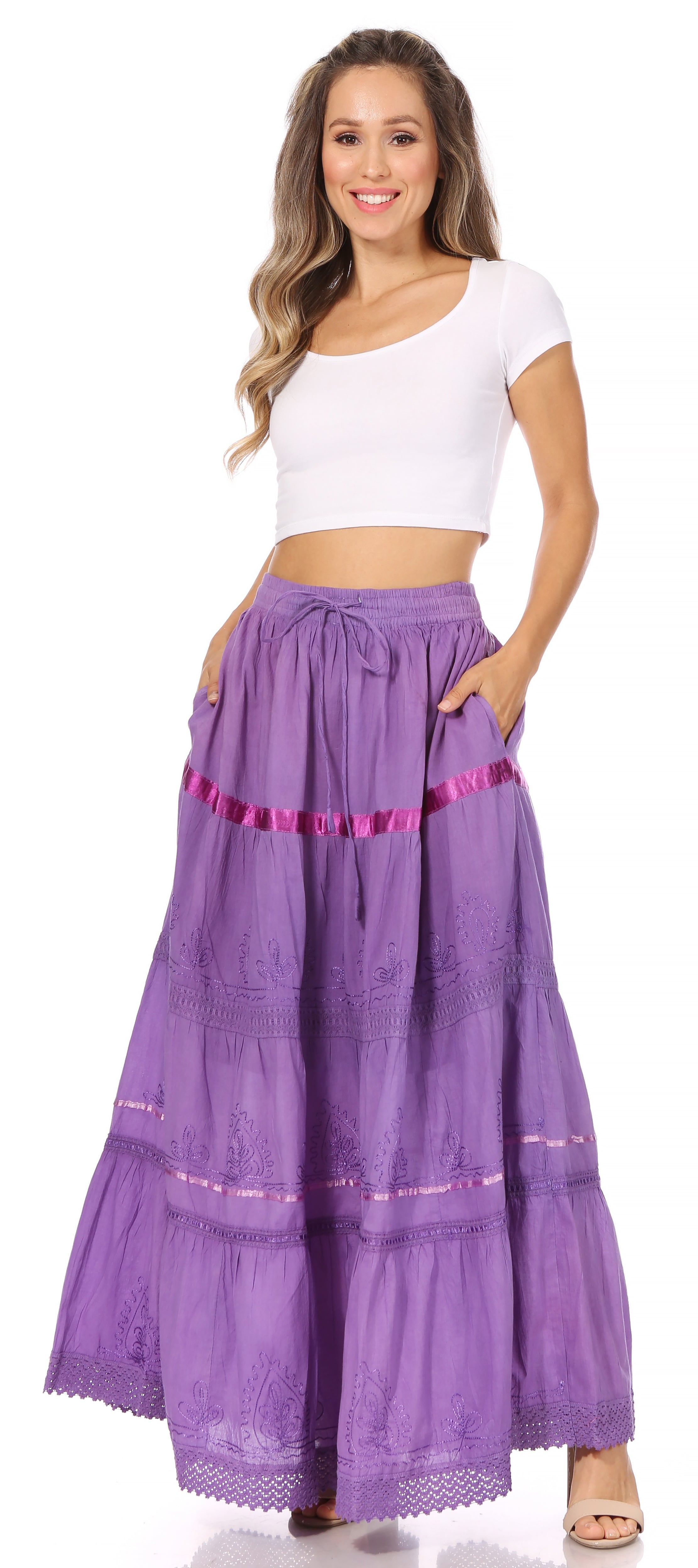 Woman wearing a long purple skirt with white top on a white background