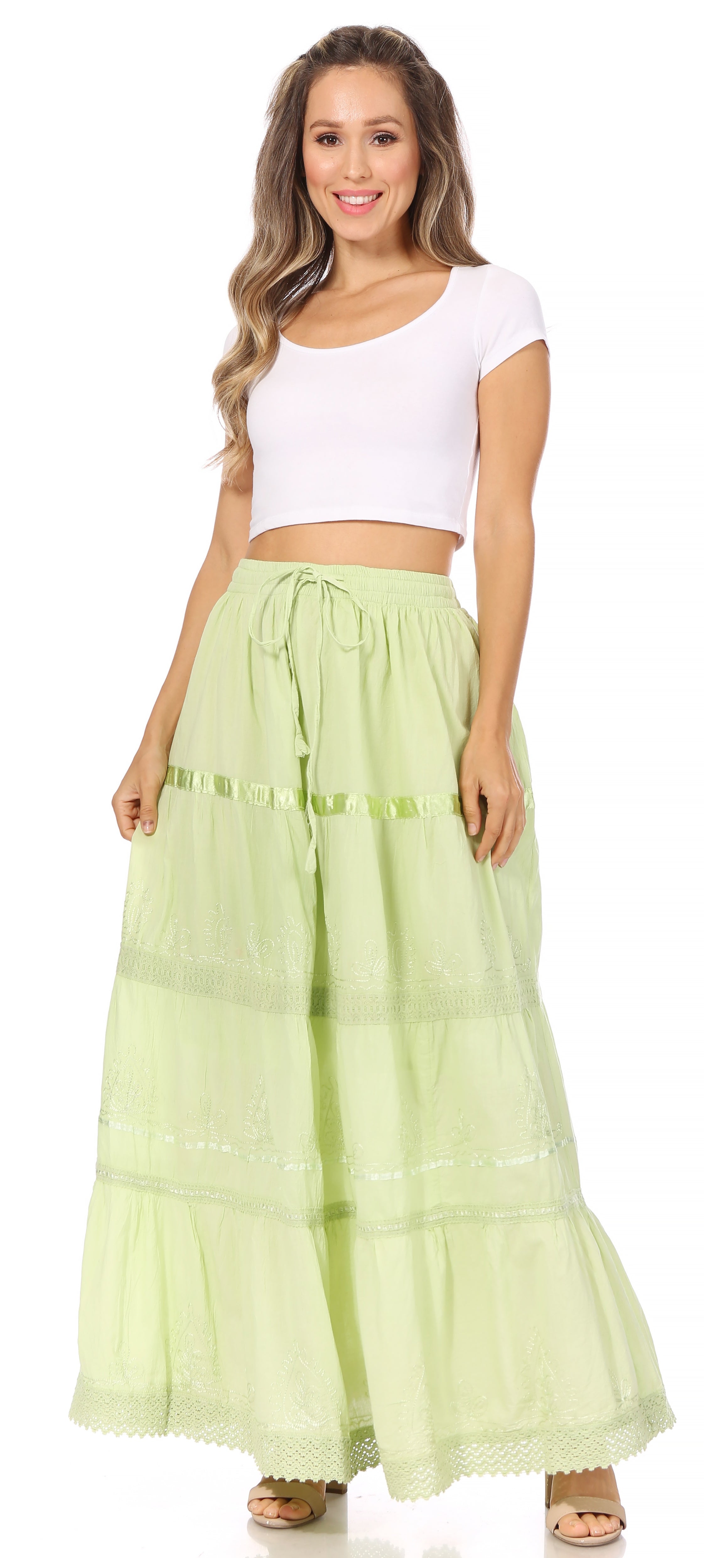 Woman wearing a light green skirt with white top on a white background