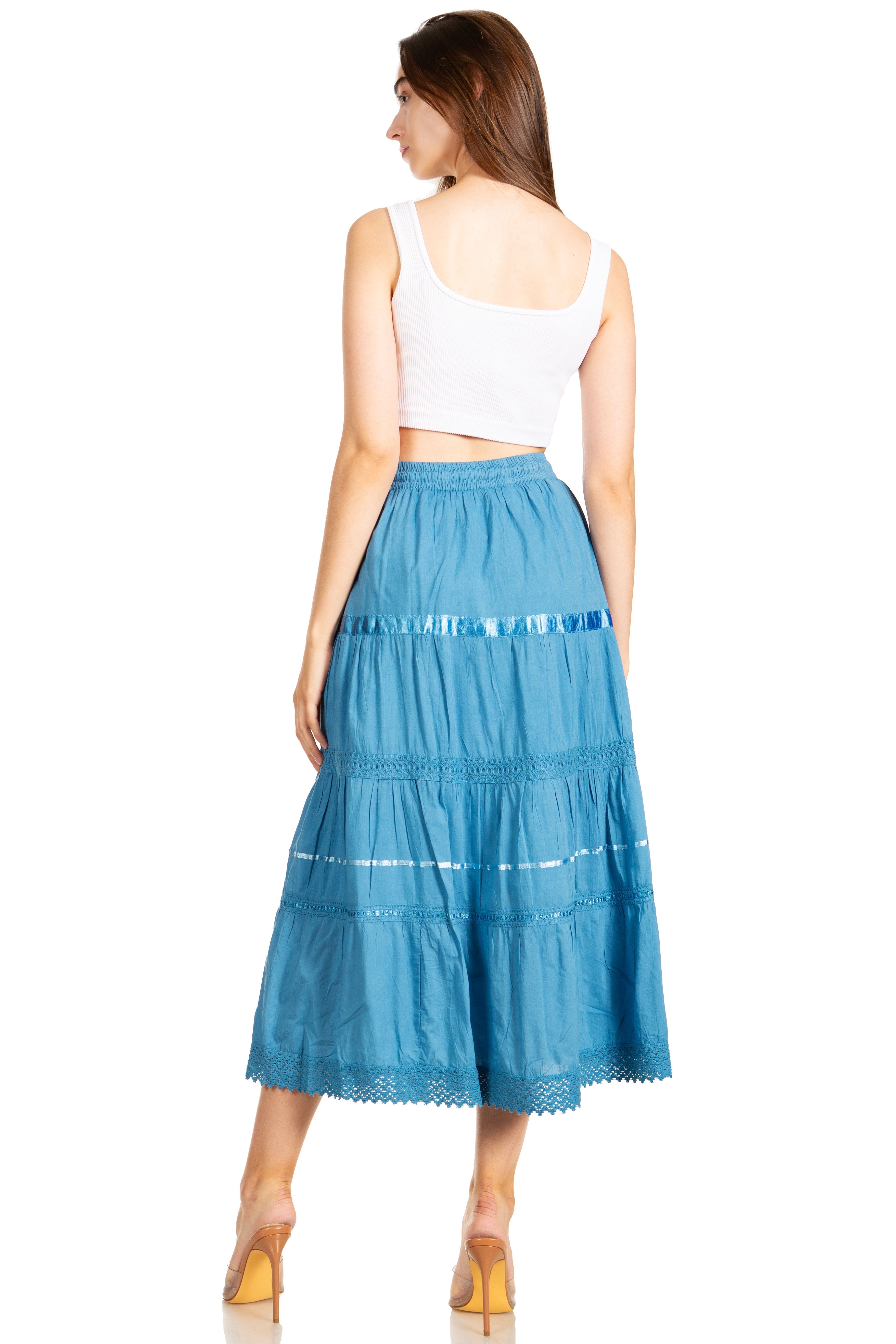 Woman wearing a blue tiered skirt and white top on a white background
