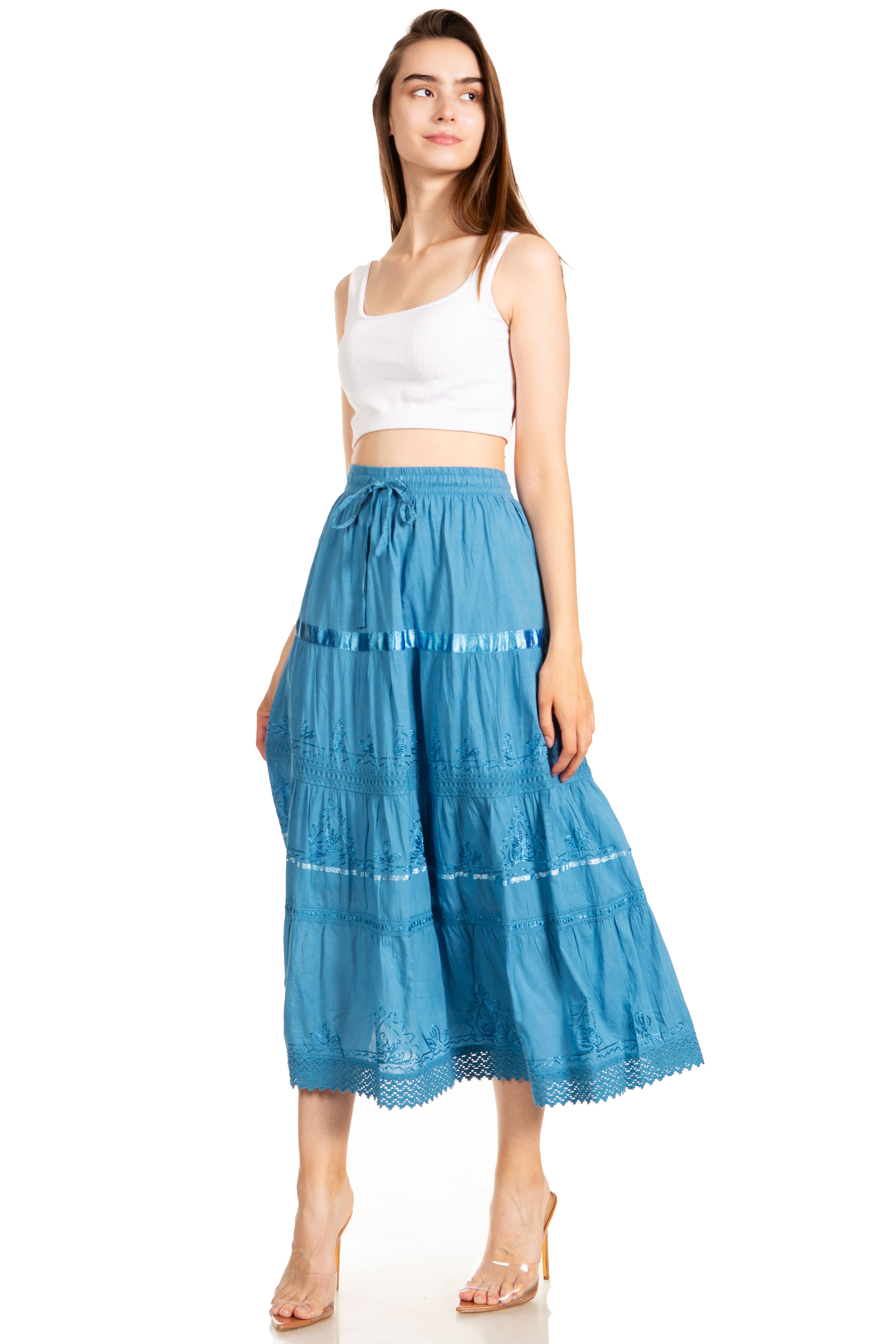 Woman wearing a white top and blue tiered skirt on a white background