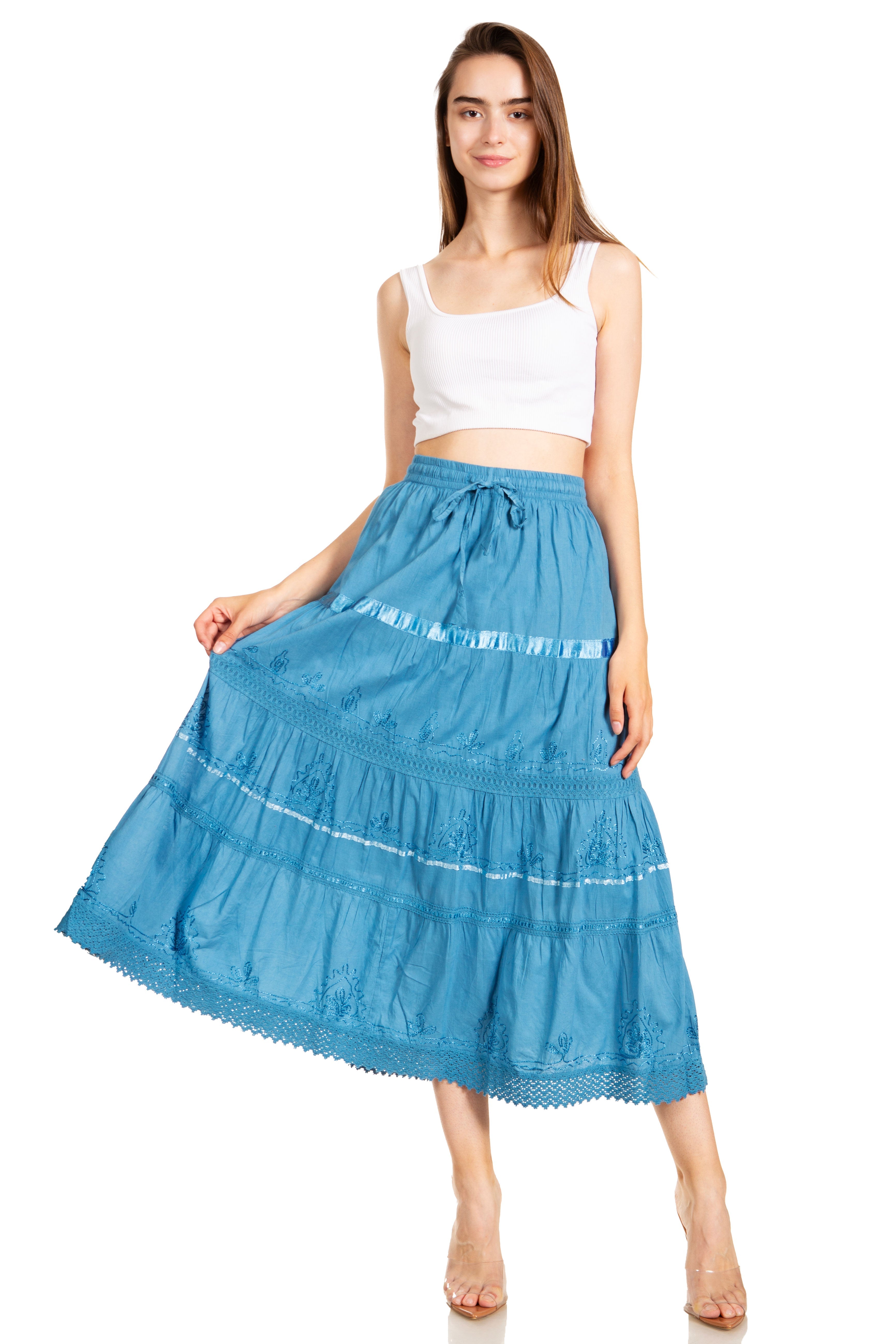 Woman wearing a blue tiered skirt and white top on a white background