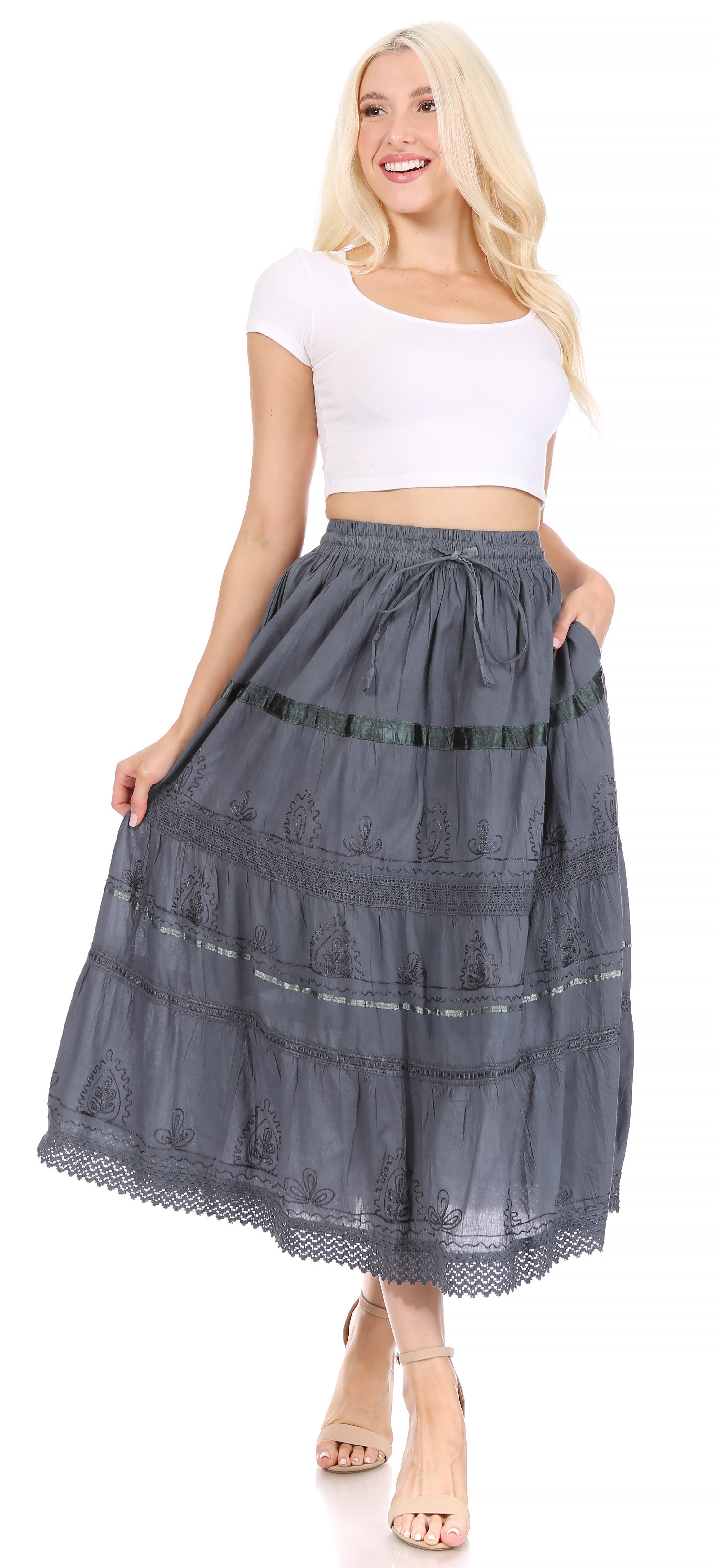 Woman wearing a white top and blue tiered skirt on a white background