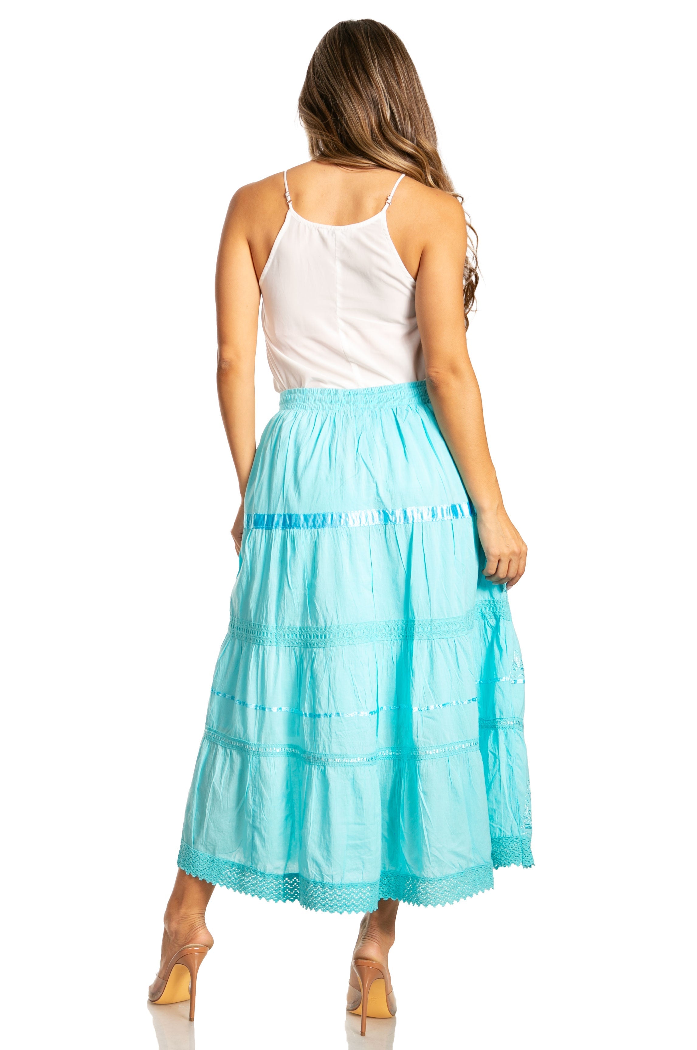 Woman wearing a white top and turquoise skirt on a white background