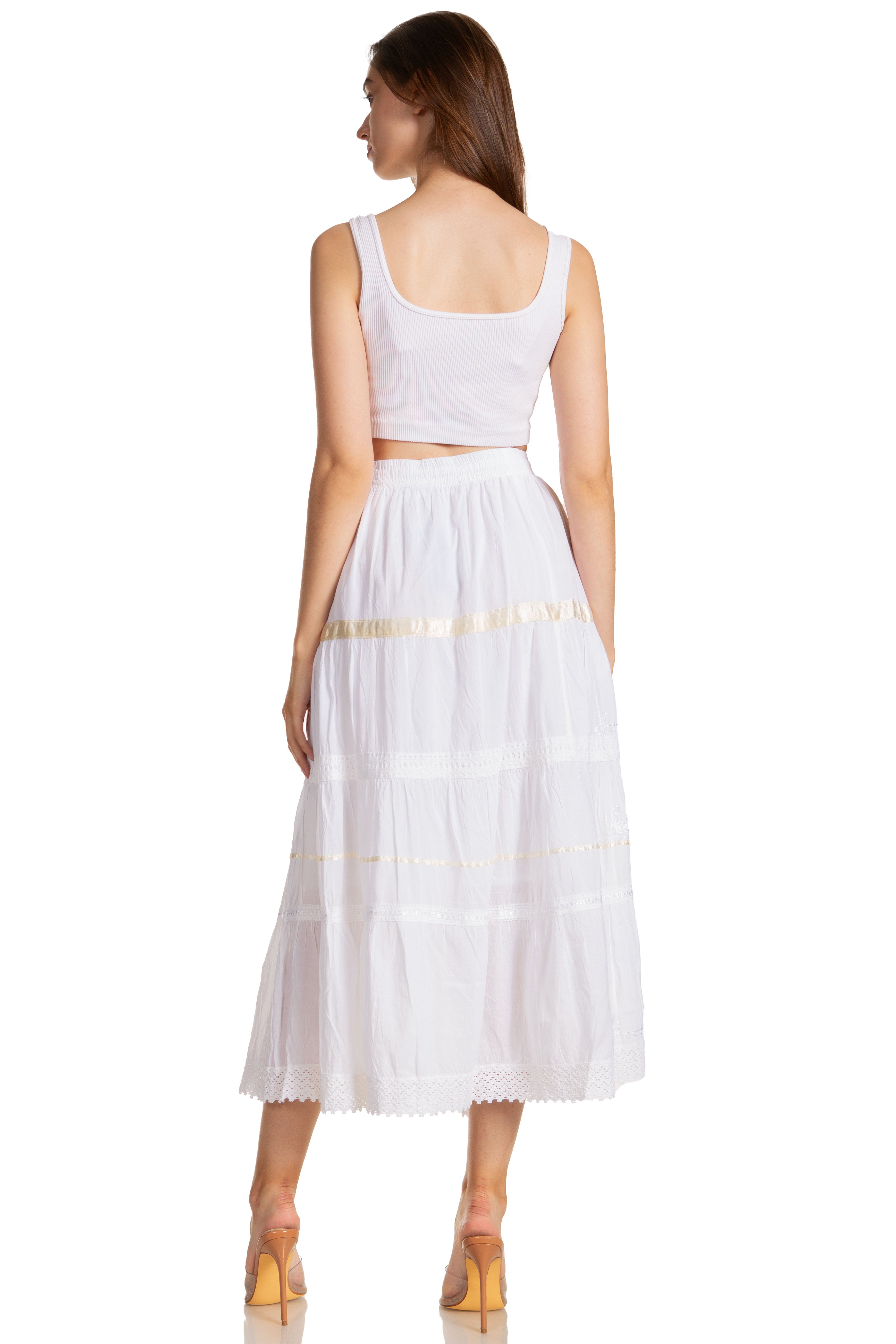Woman wearing a white dress with a gold waistband on a white background