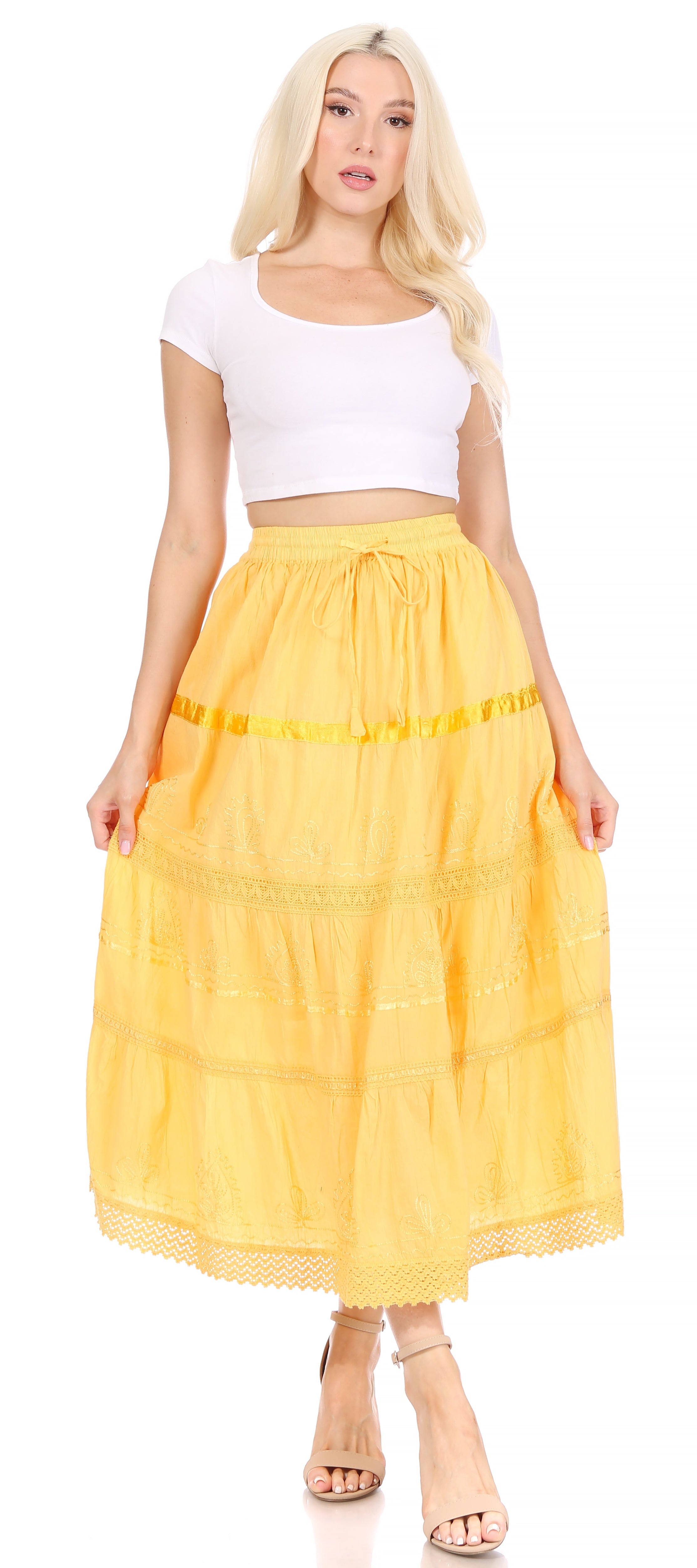 Woman wearing a yellow skirt and white top on a plain background