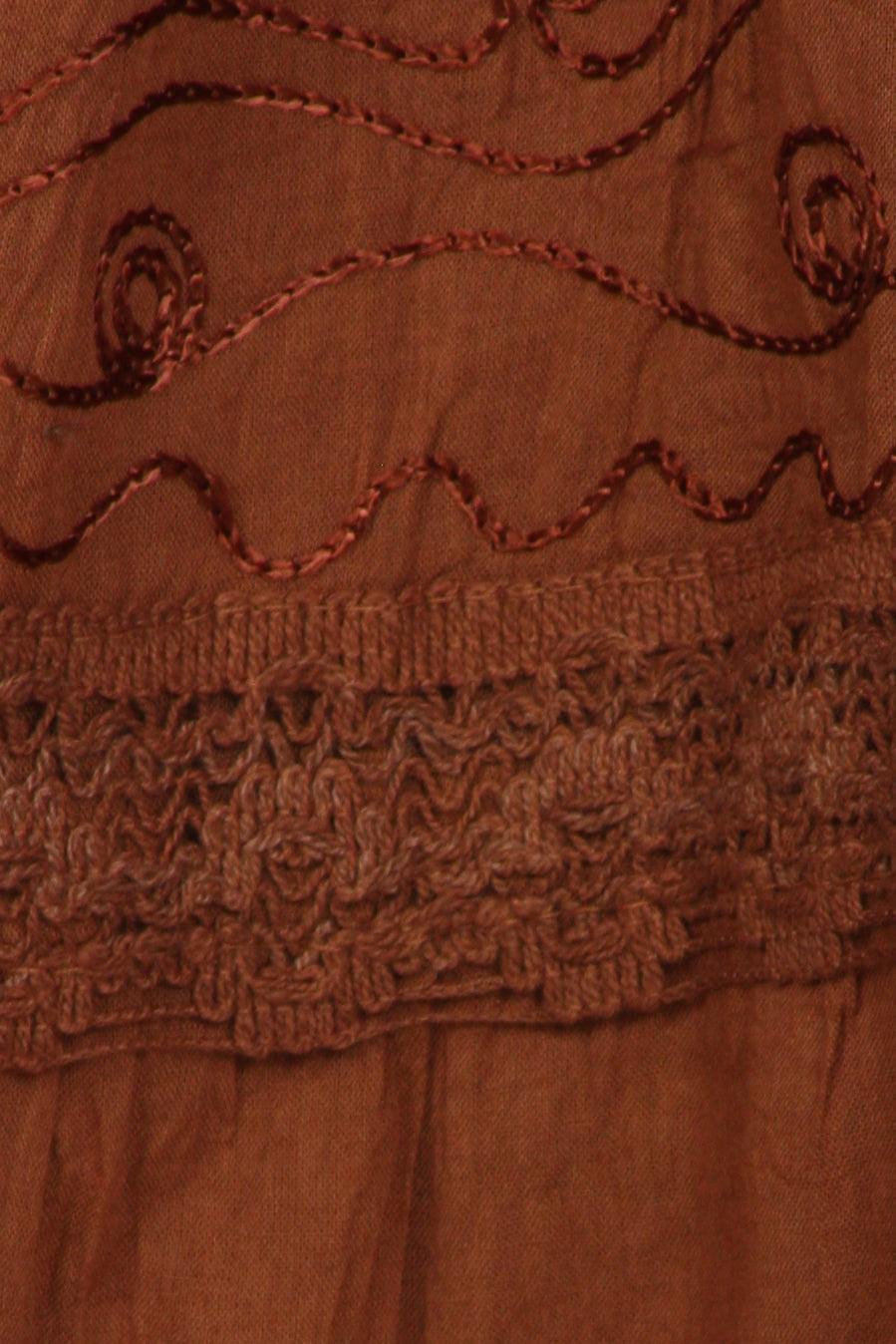 Close-up of brown fabric with embroidered patterns