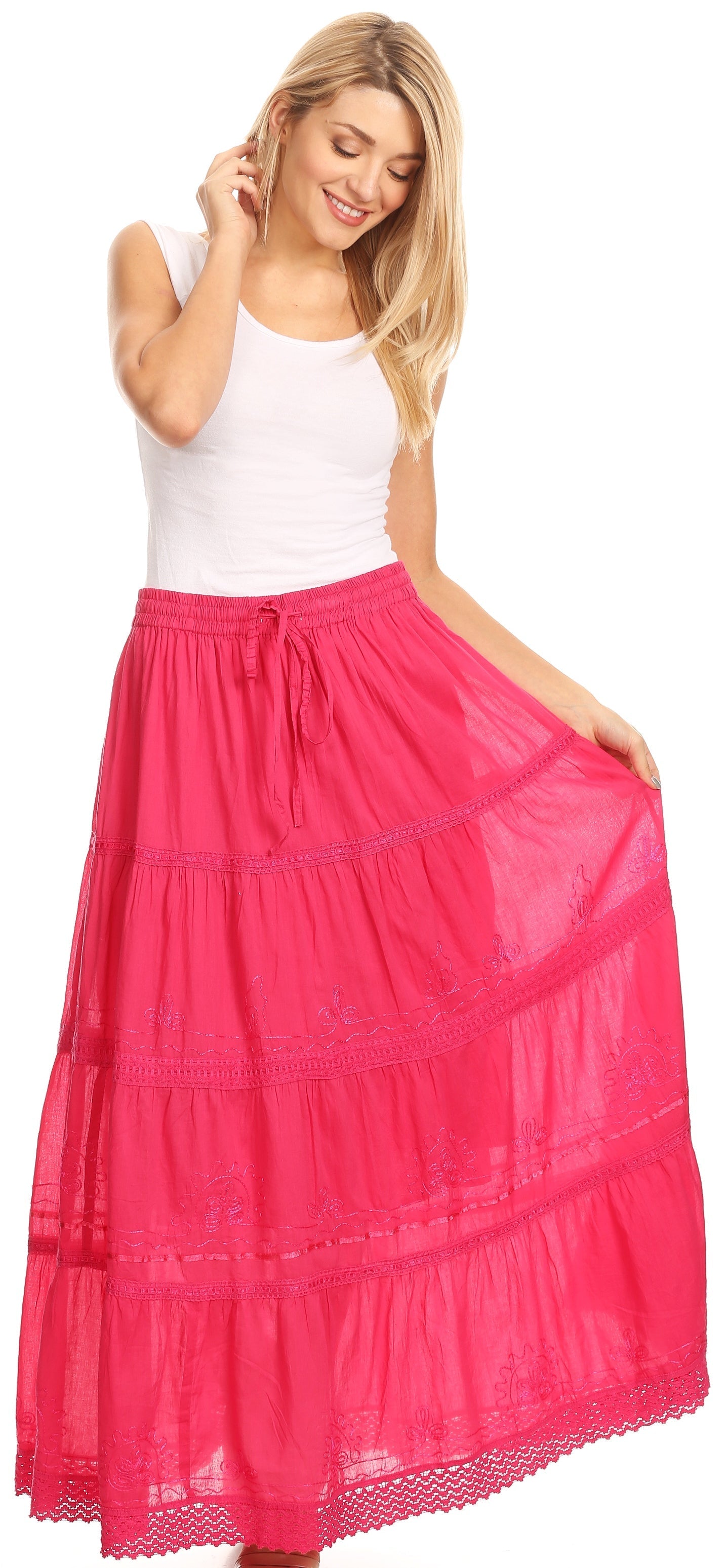 Woman wearing a long pink skirt with a white top on a white background