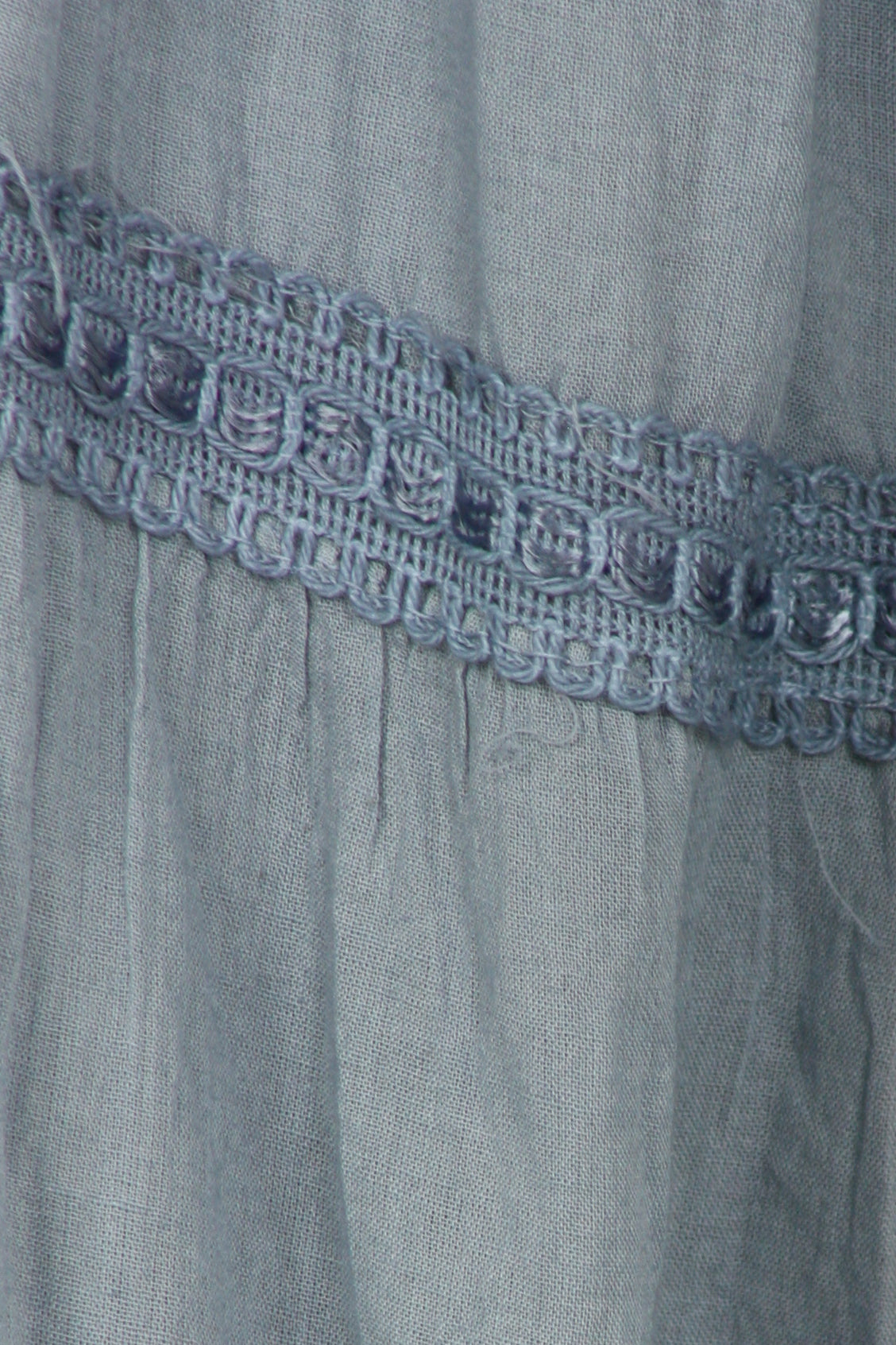 Close-up of a light blue dress with lace trim