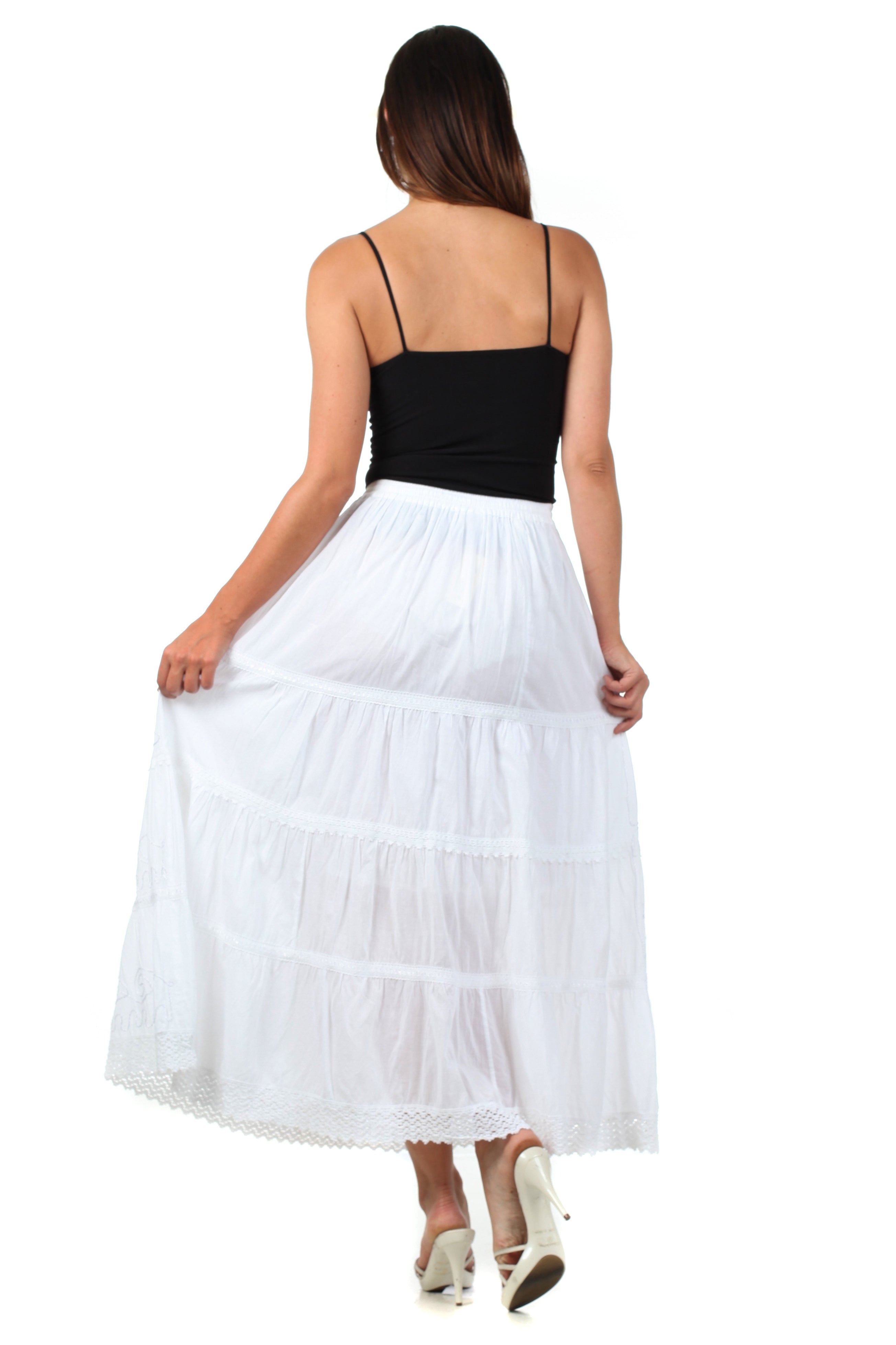 Woman wearing a black top and white skirt on a white background