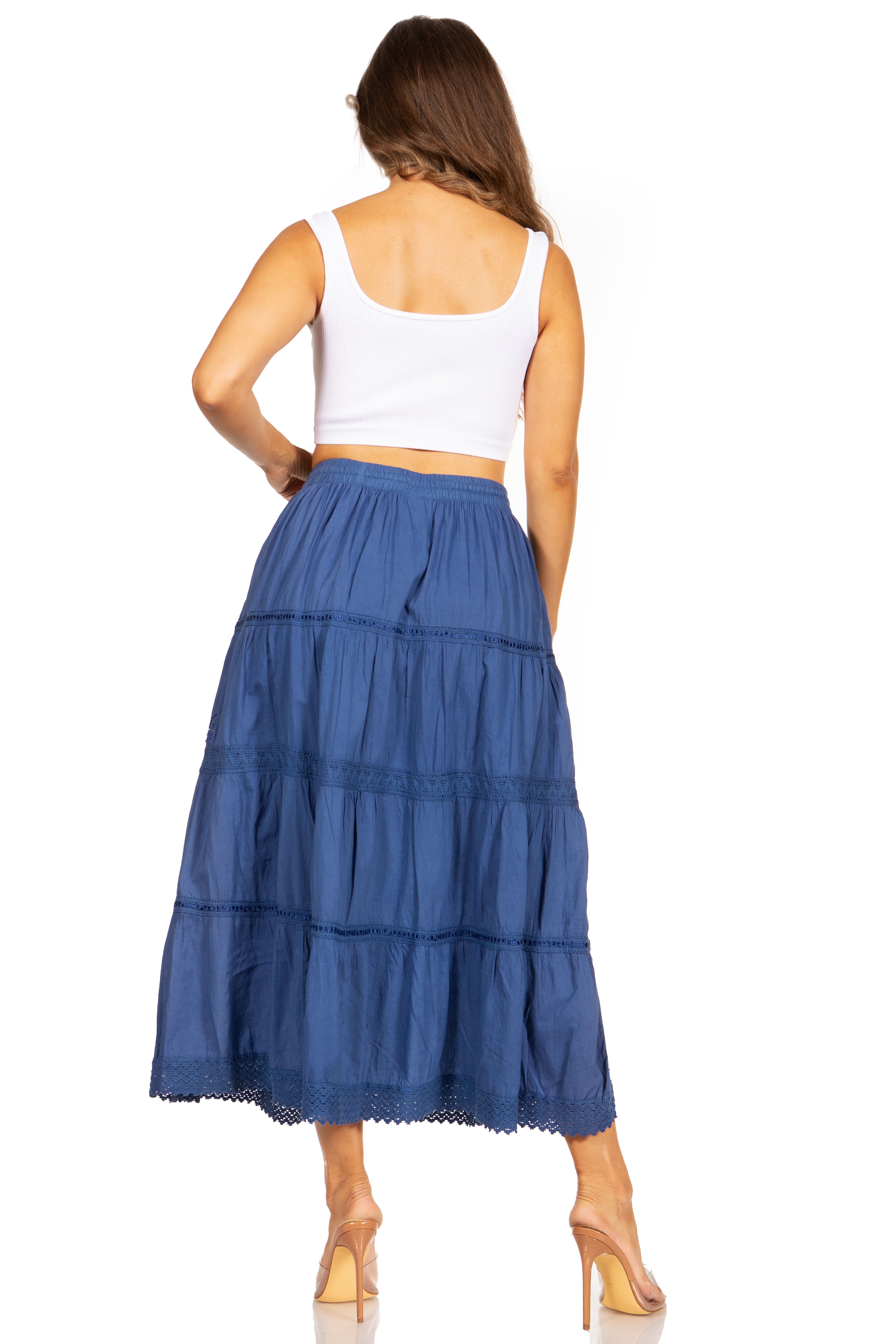Woman wearing a blue tiered skirt and white top on a white background