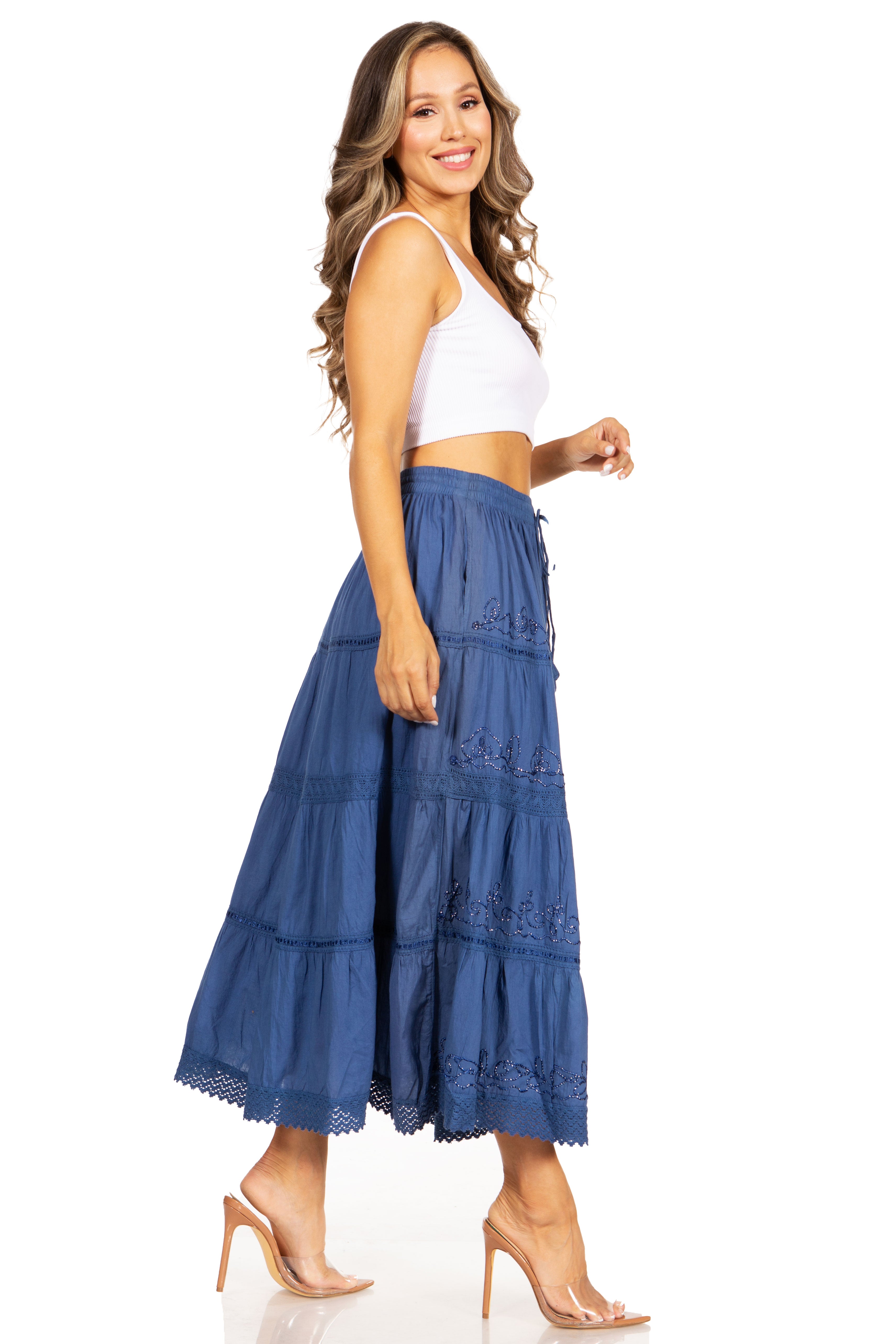 Woman wearing a blue tiered skirt and white top on a white background