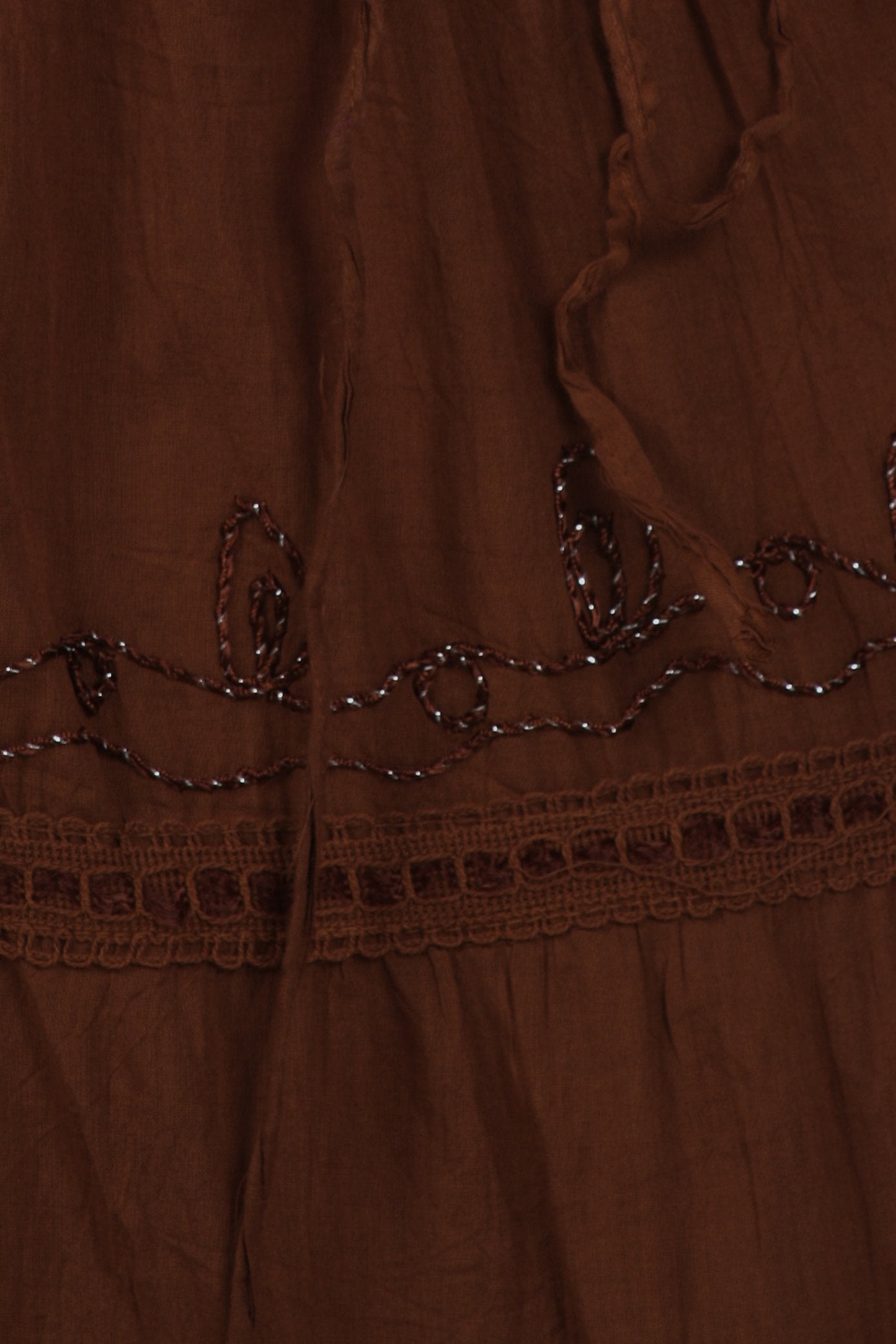 Close-up of a brown fabric with intricate beadwork