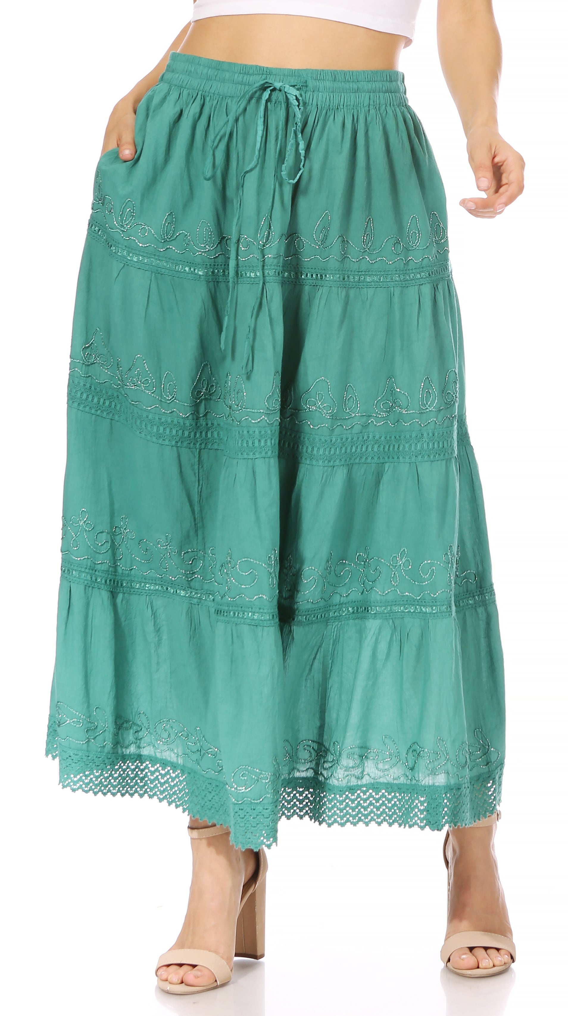 Green lace-trimmed pants worn by a person on a white background
