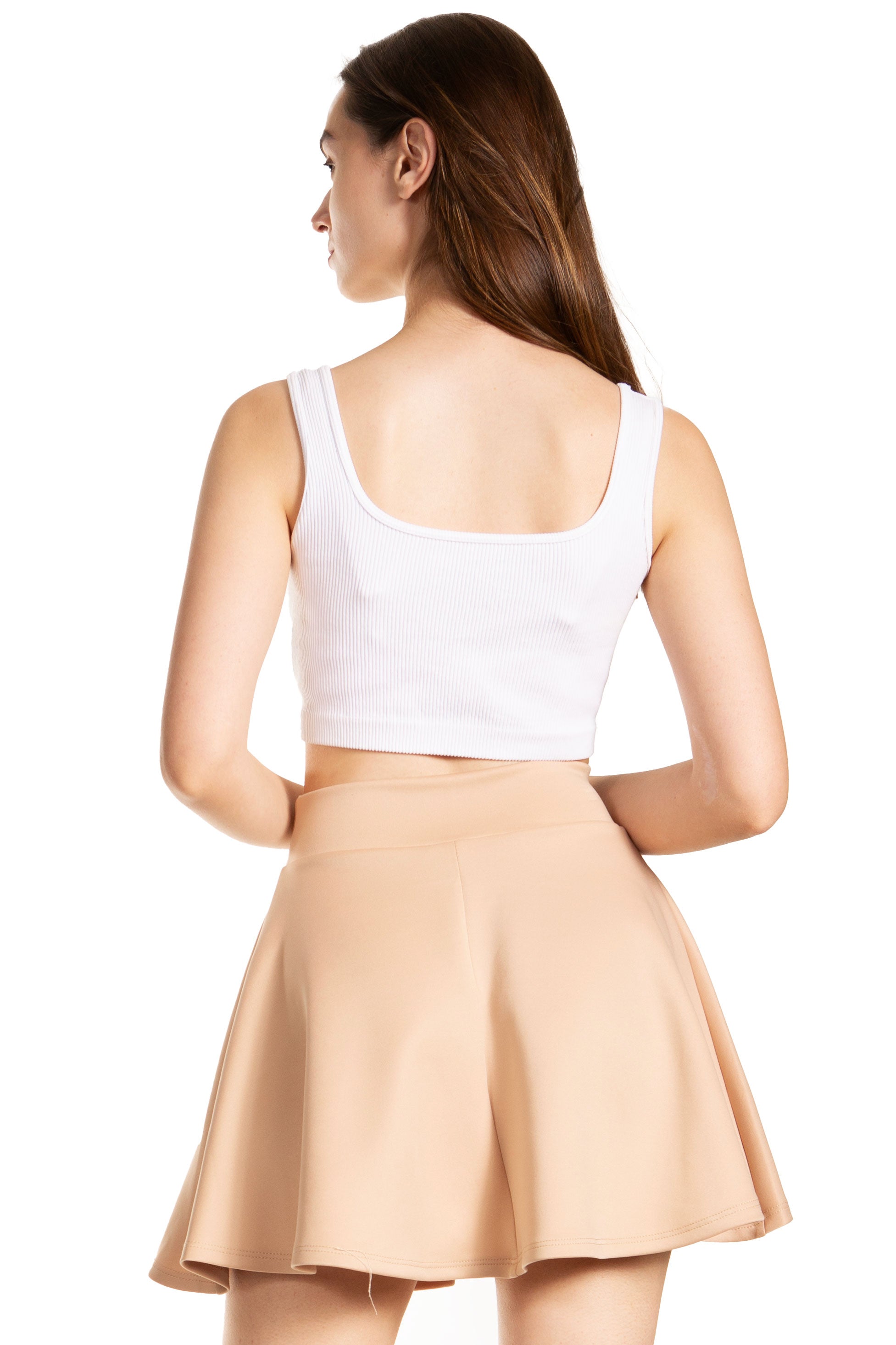 Woman wearing a white crop top and beige skirt on a white background