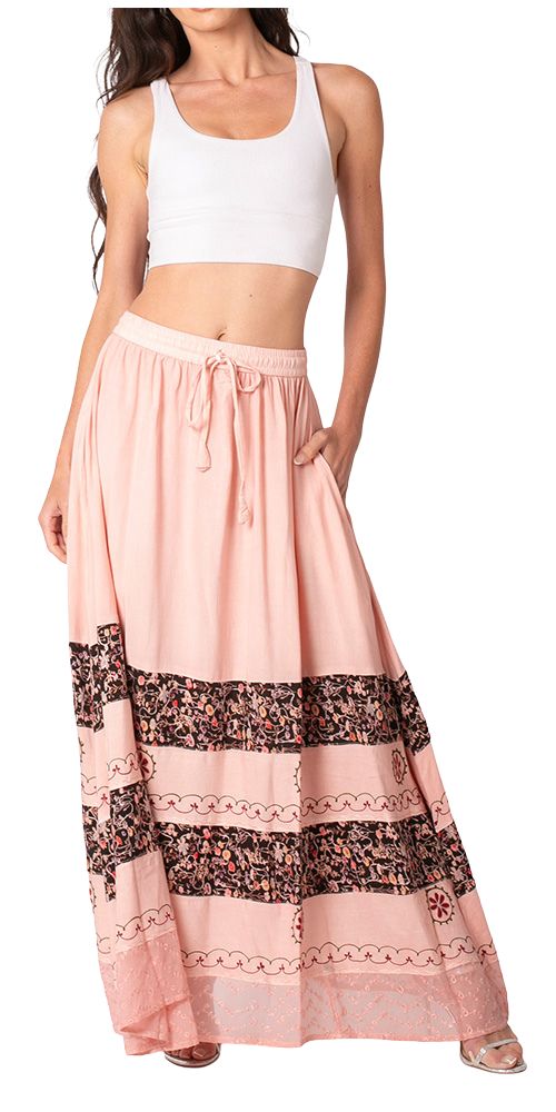 Woman wearing a white crop top and pink skirt with lace details on a white background