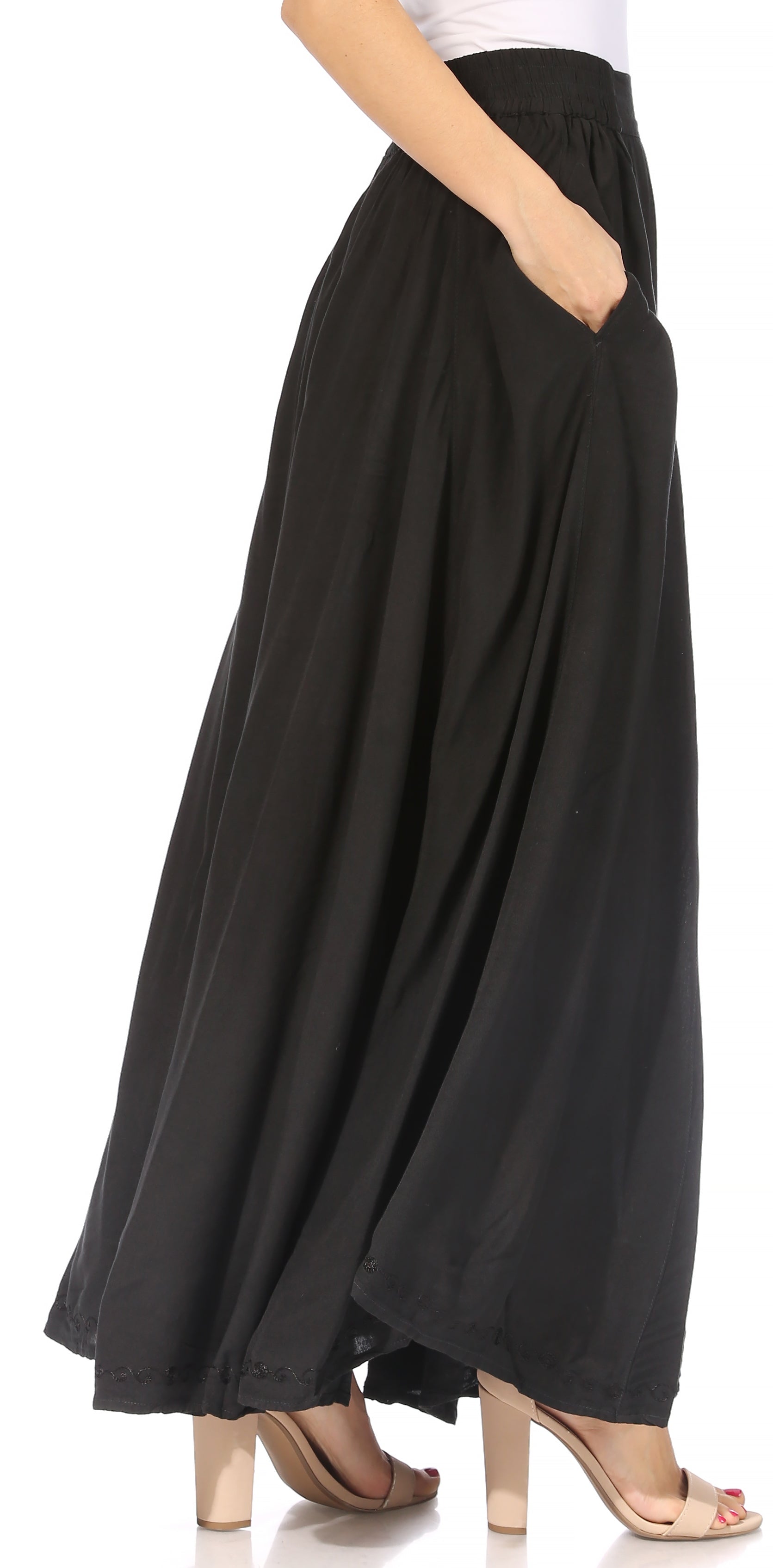 Black flowing skirt worn by a person on a white background