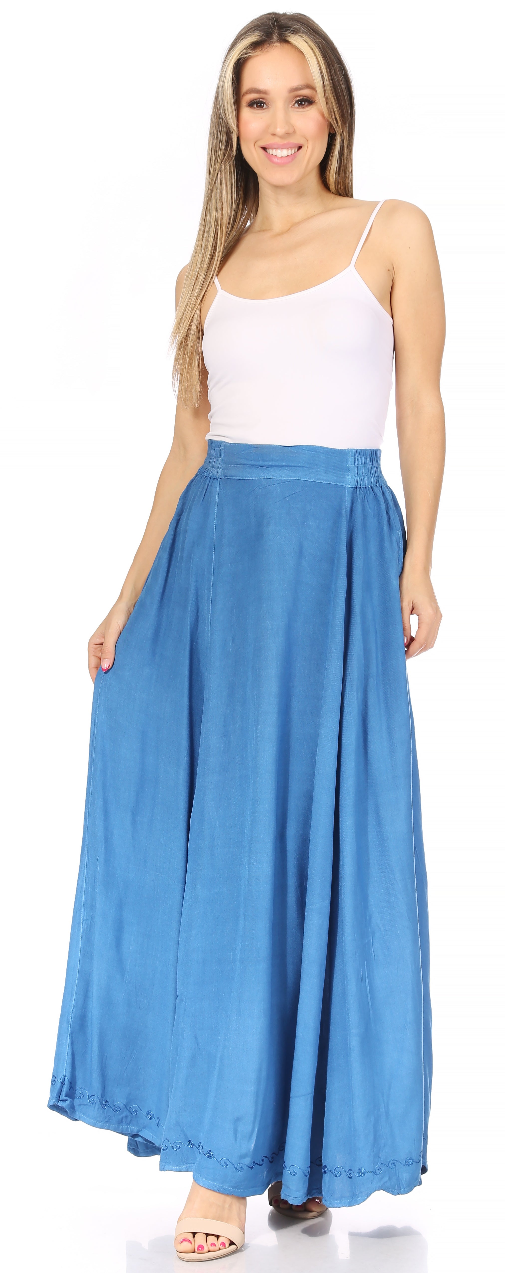 Woman wearing a white top and blue maxi skirt on a white background