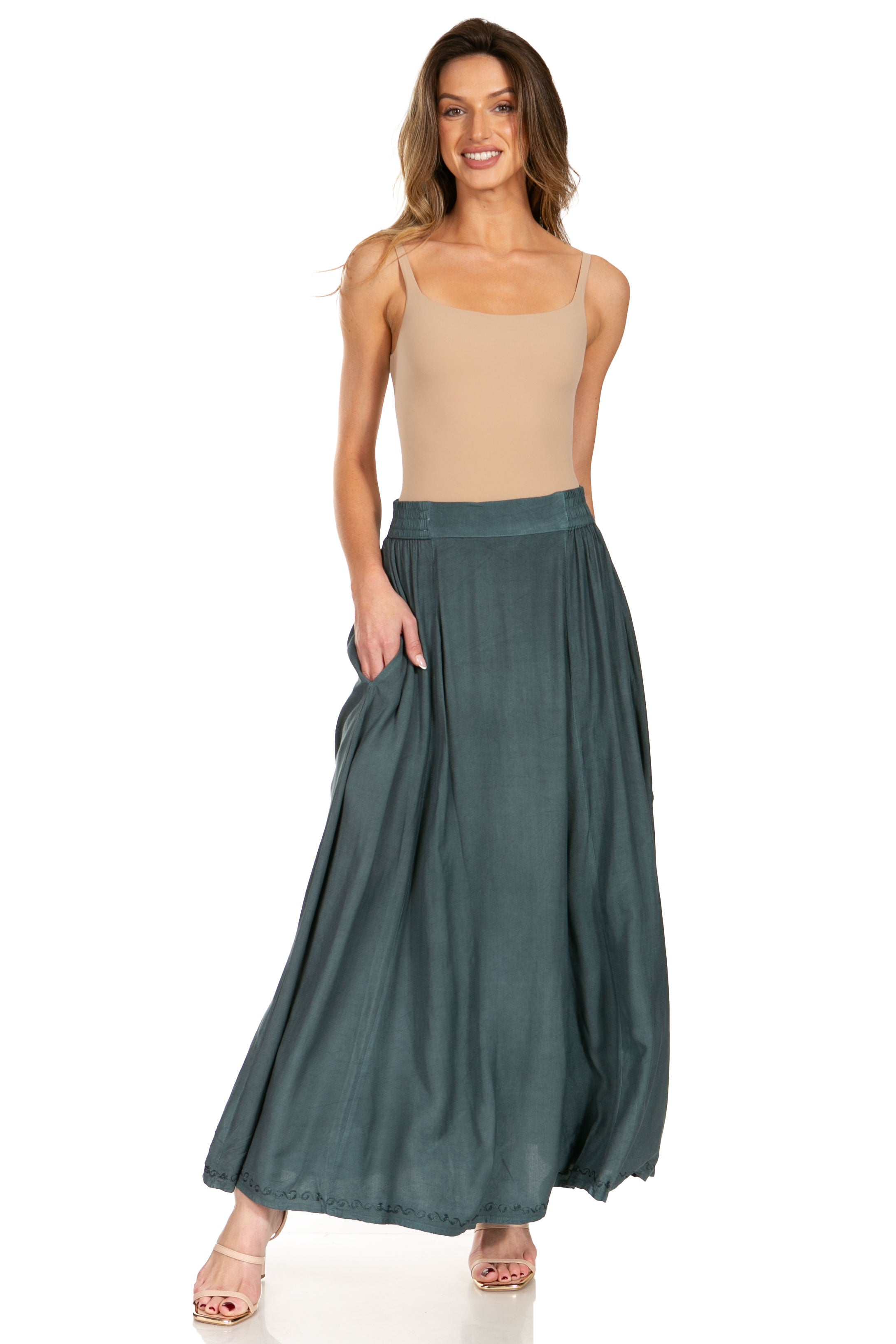 Woman wearing a beige top and green skirt on a white background