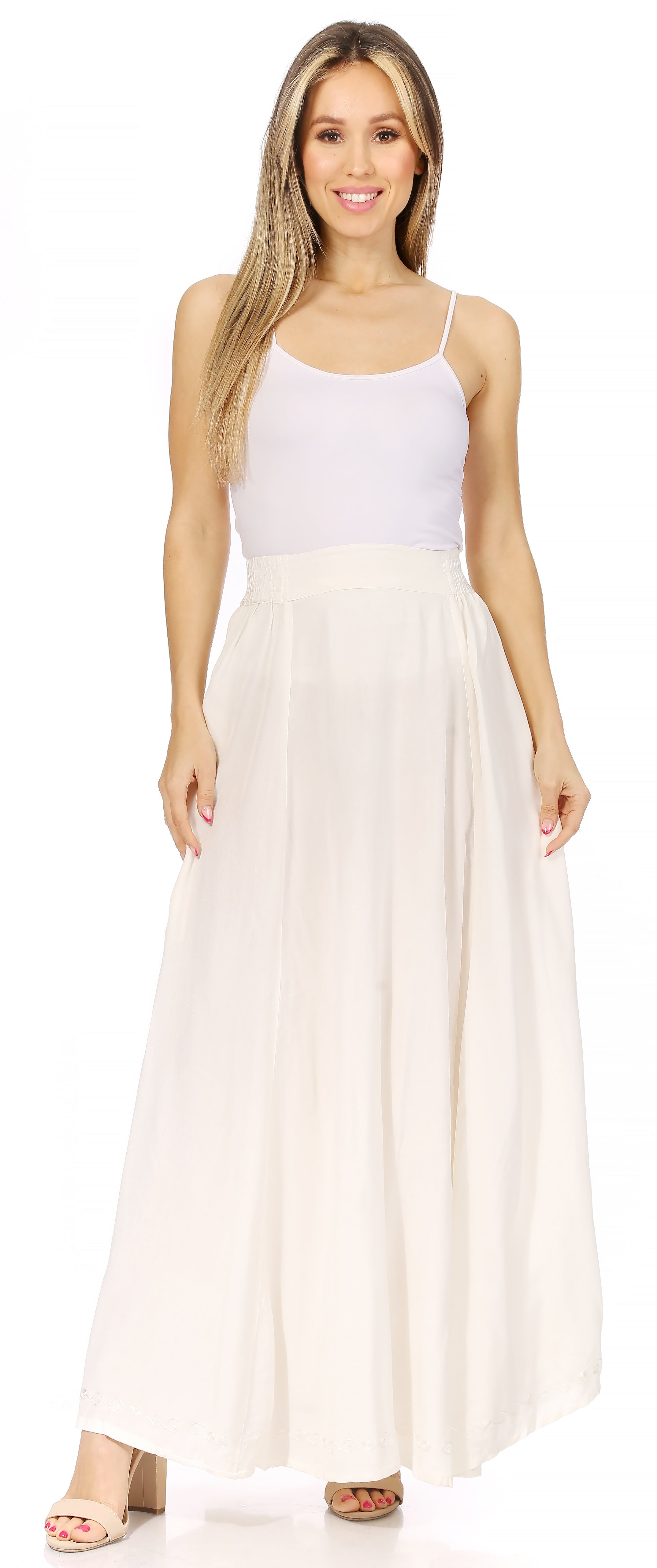 Woman wearing a white sleeveless top and long cream skirt on a white background