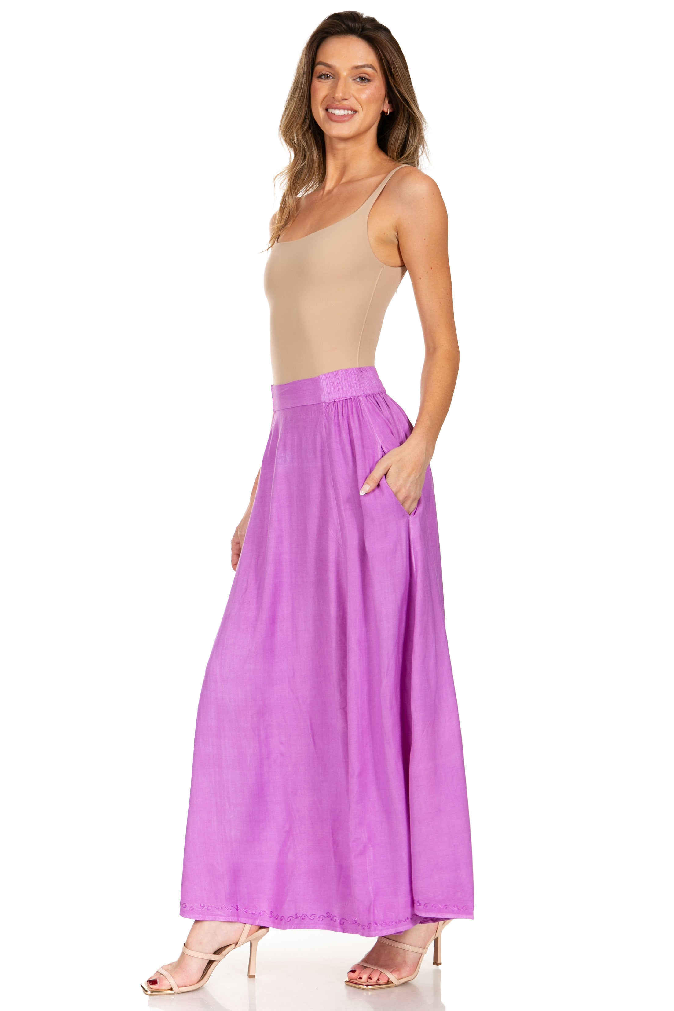 Woman wearing a beige top and purple skirt on a white background